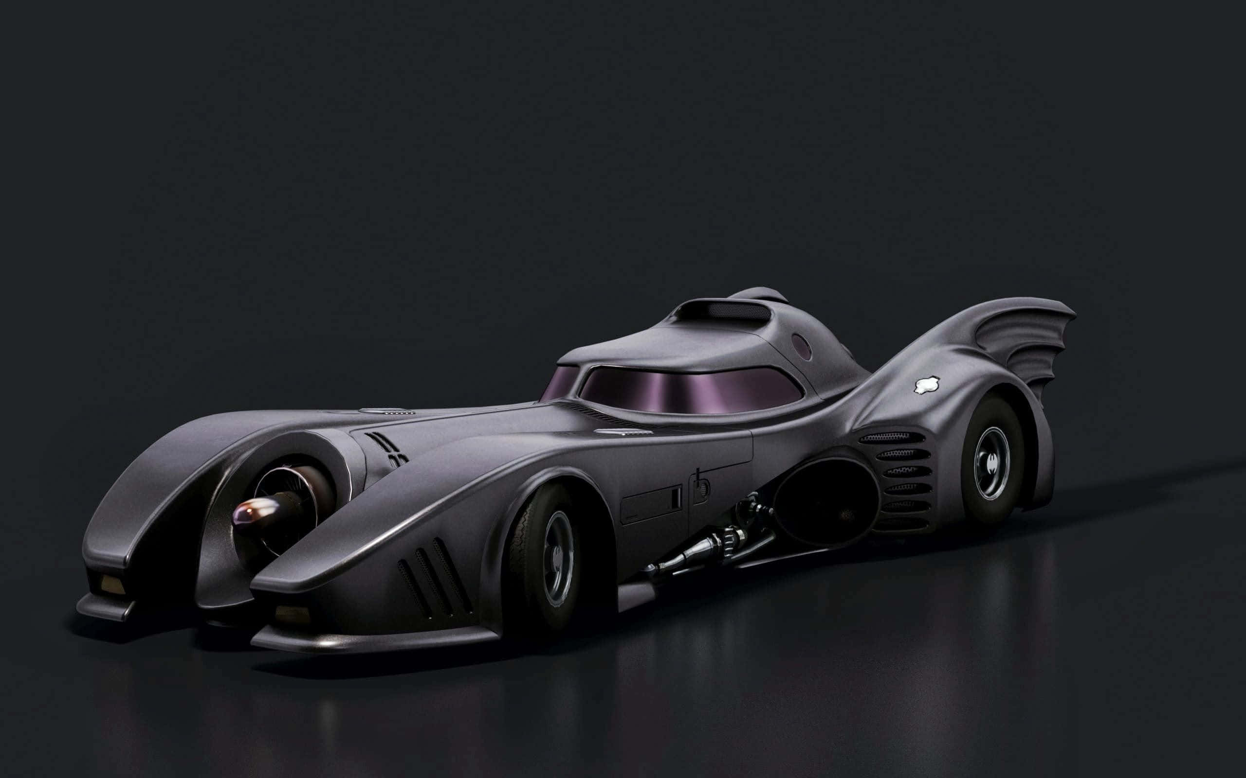 Batmobile Desktop 桌布 壁紙 — 一架時尚的消光黑色蝙蝠車，帶有蝙蝠般的翅膀和發光的紫色點綴，停放在深色反光表面上。