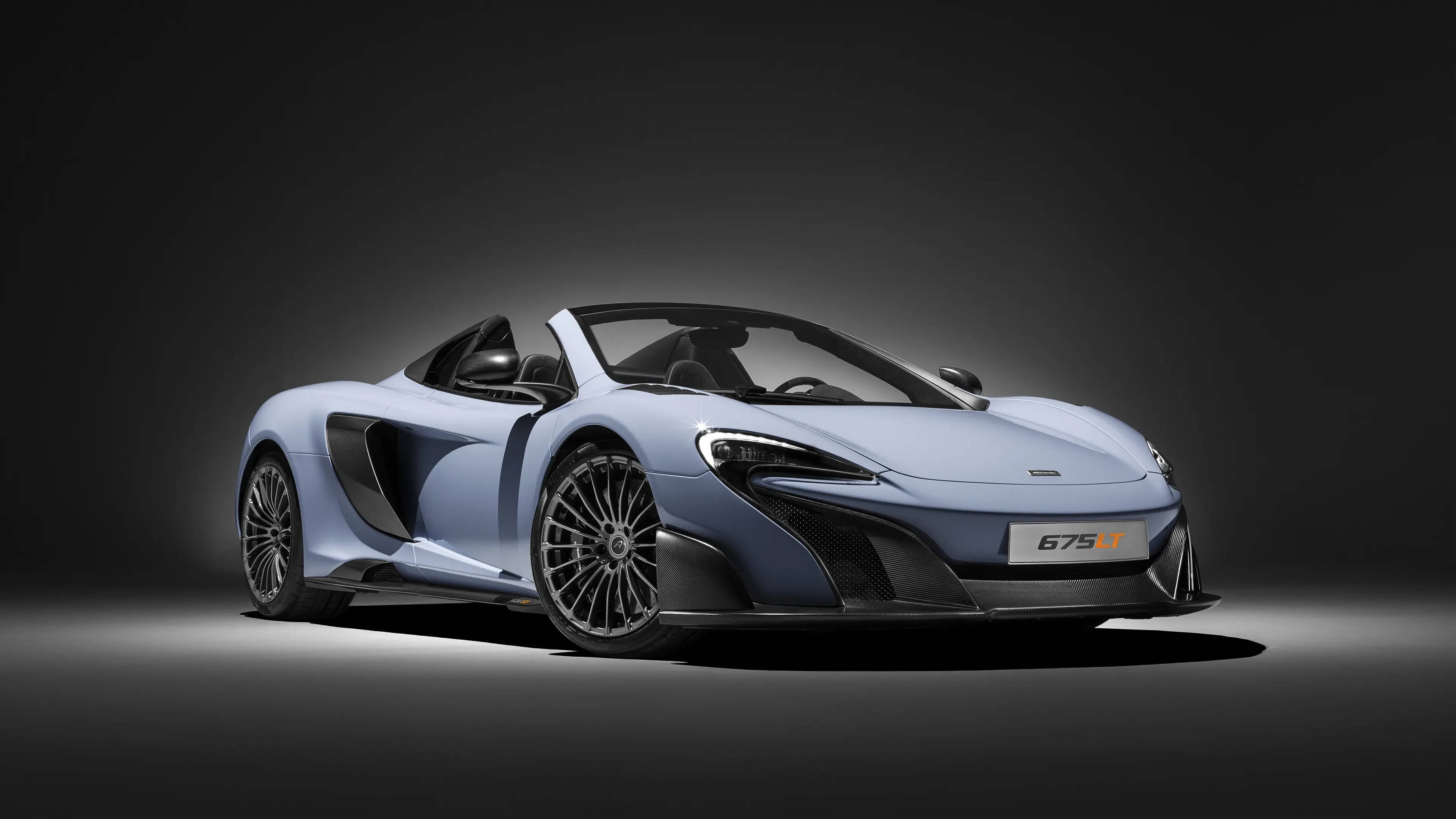 跑車 桌布 壁紙 — 一架時尚的淺藍色McLaren 675LT跑車，帶有黑色飾件和銀色輪圈，在深灰色背景下的戲劇性工作室燈光中展示。