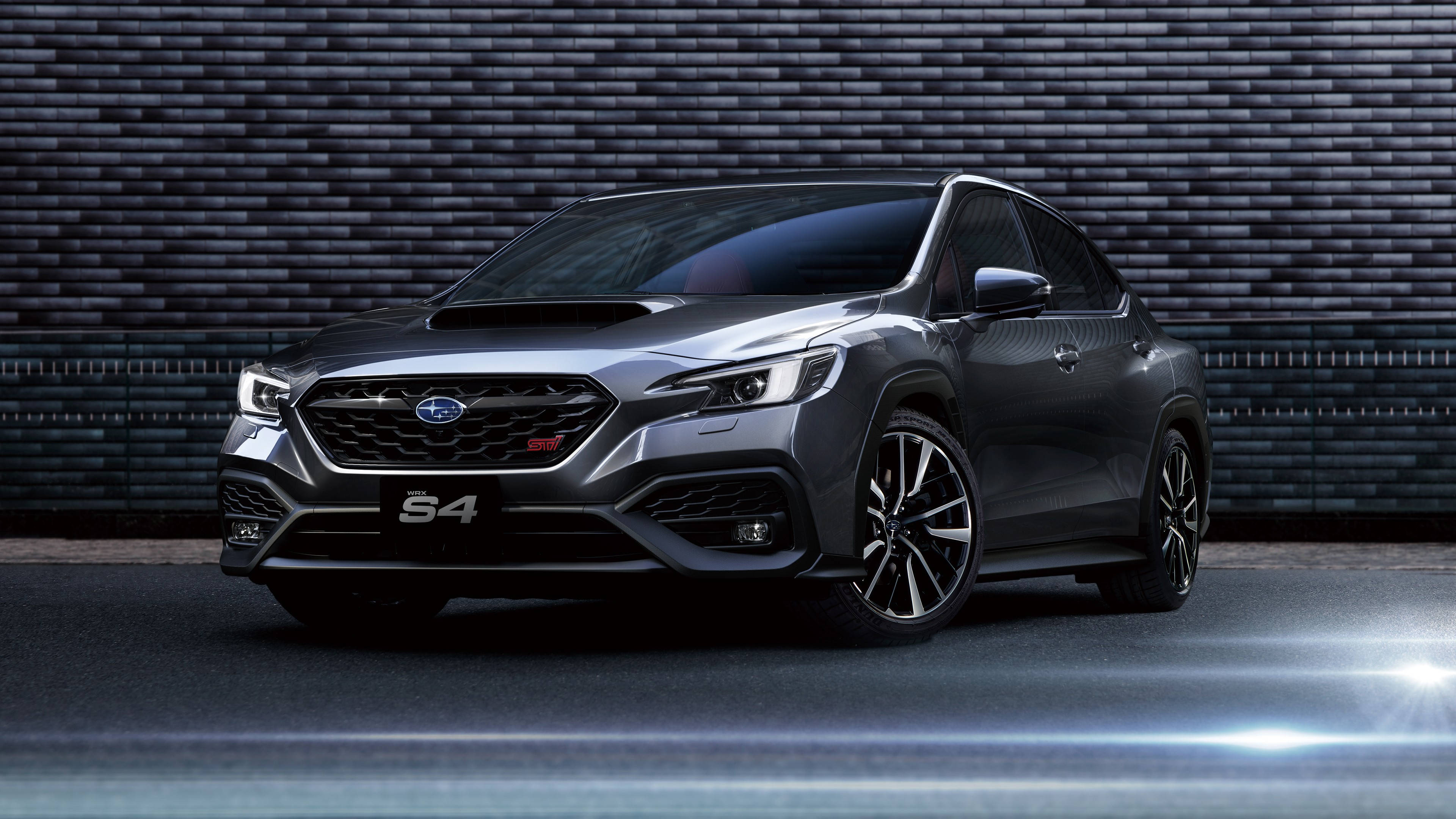 昴 桌布 壁紙 — 一架時尚的灰色 Subaru S4 性能 SUV 在戲劇性的工作室燈光下，停靠在深色紋理磚牆前。