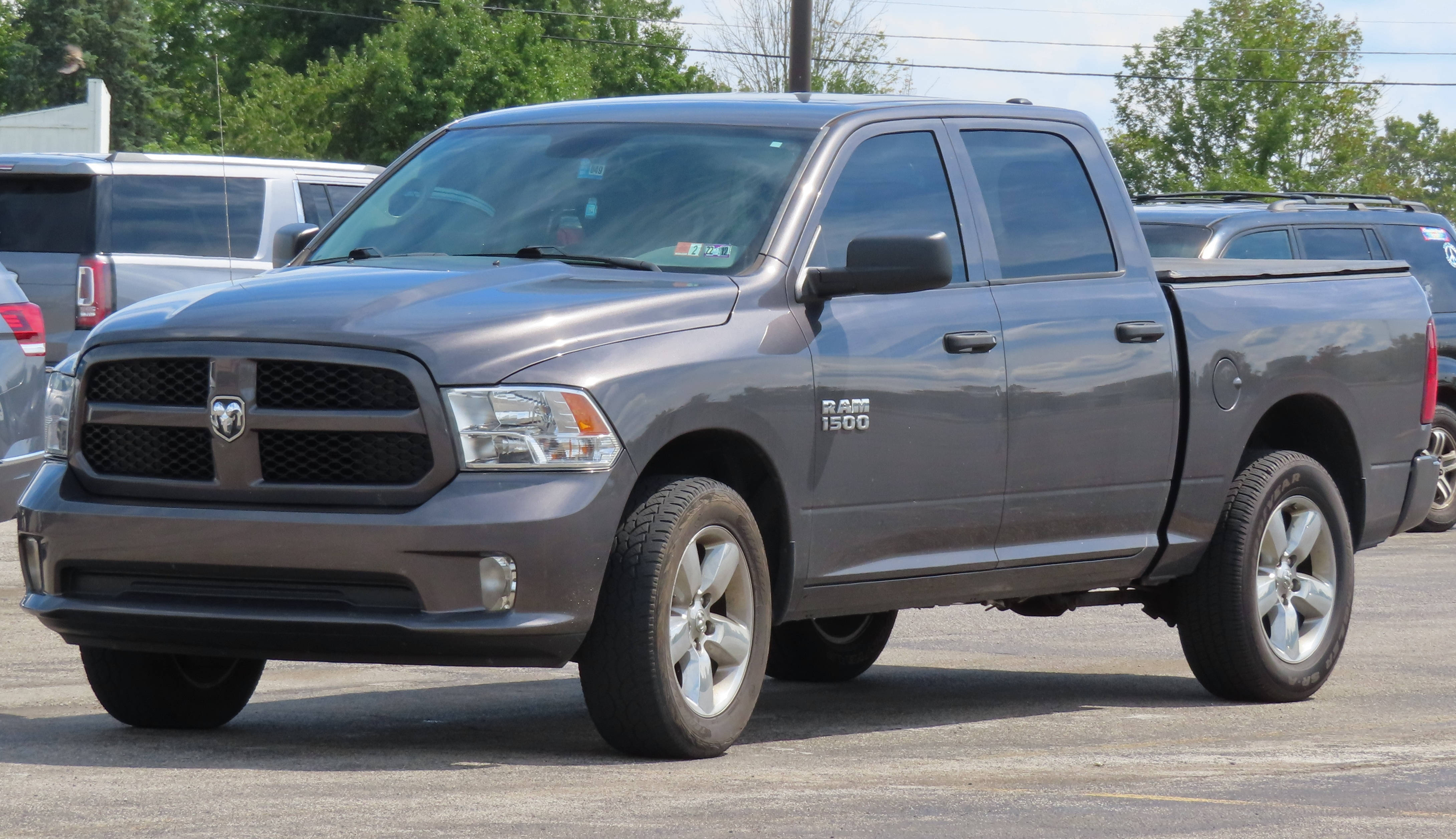 Pickup Truck 桌布 壁紙 — 一架時尚的灰色道奇 Ram 1500 皮卡車停放在停車場，背景有樹木和其他車輛。