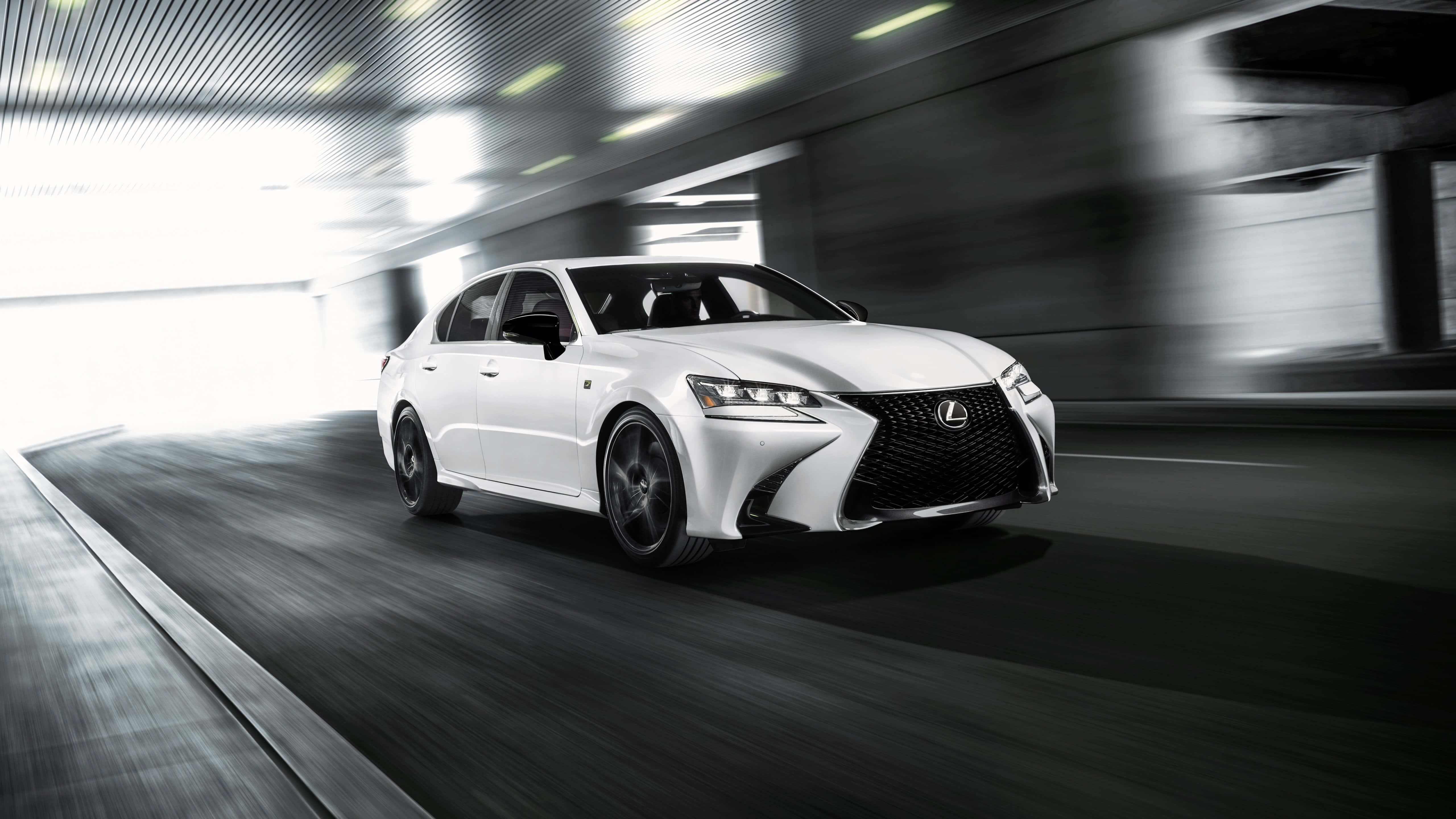 Lexus Gs 桌布 壁紙 — 一架時尚的白色Lexus轎車在現代隧道中疾馳，動態模糊強調了速度。