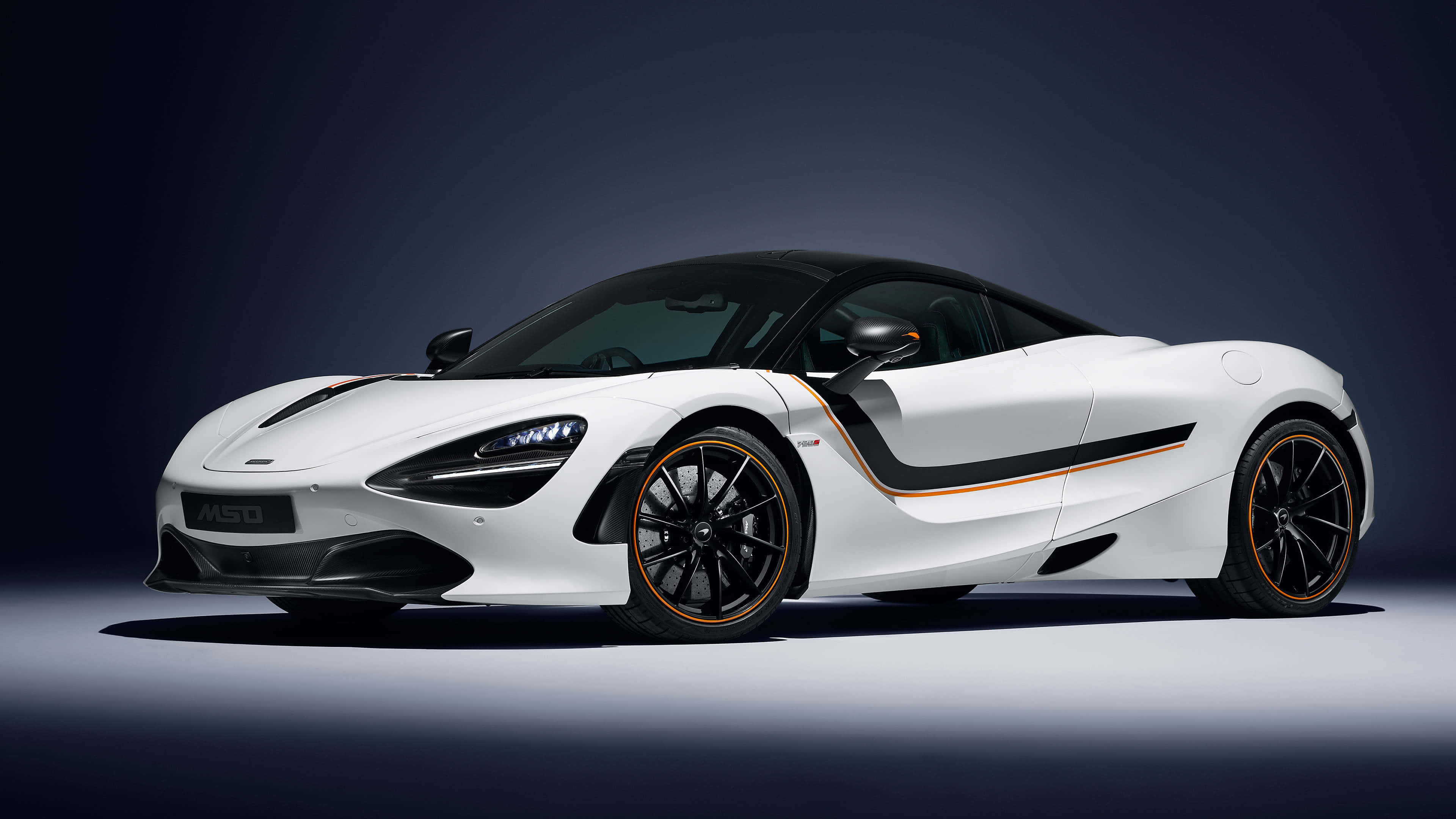 4K Mclaren 720s 桌布 壁紙 — 一架時尚的白色McLaren 720S跑車，帶有黑色和橙色點綴，在深藍色背景和聚光燈的戲劇性工作室環境中展示。