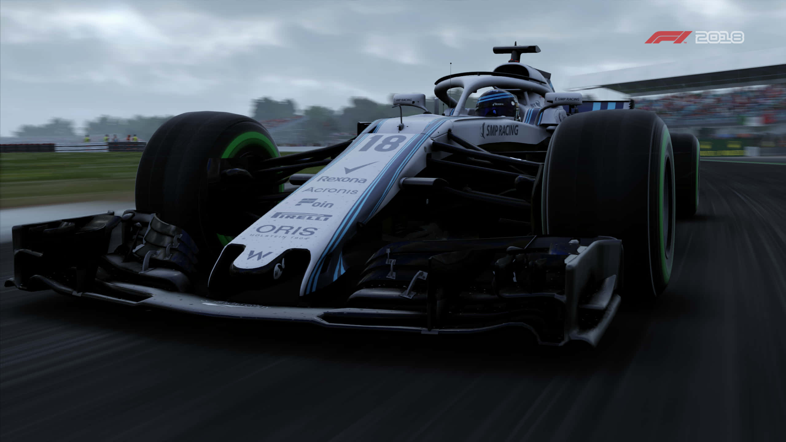 Formula One 桌布 壁紙 — 一架時尚的白色和藍色一級方程式賽車，號碼18，在多雲的天空下於潮濕賽道上奔馳。