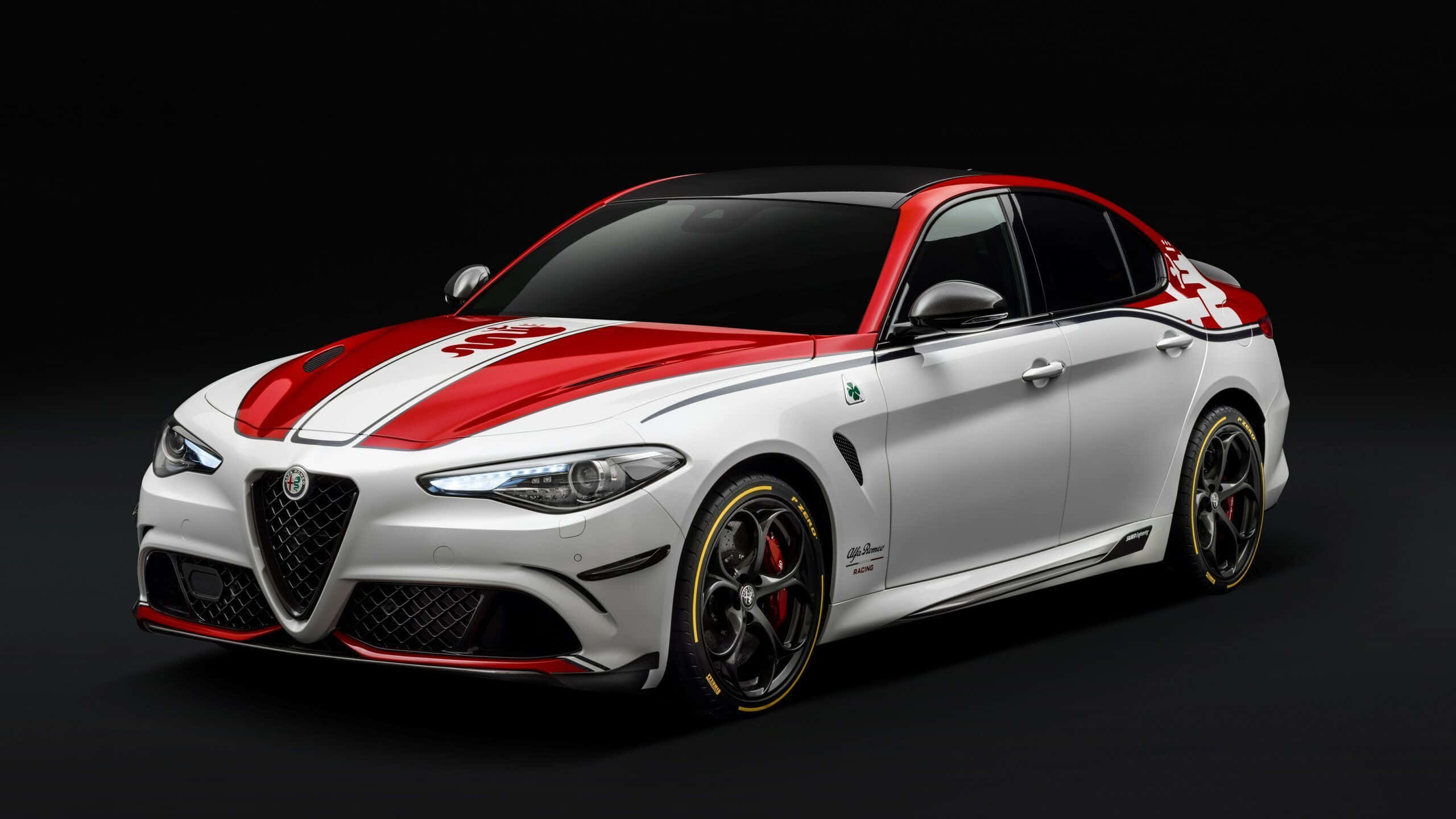 Alfa Romeo Stelvio 桌布 壁紙 — 一架時尚的白色愛快羅密歐運動房車，帶有醒目的紅色賽車條紋和黑色點綴，在深色工作室背景下蓄勢待發。