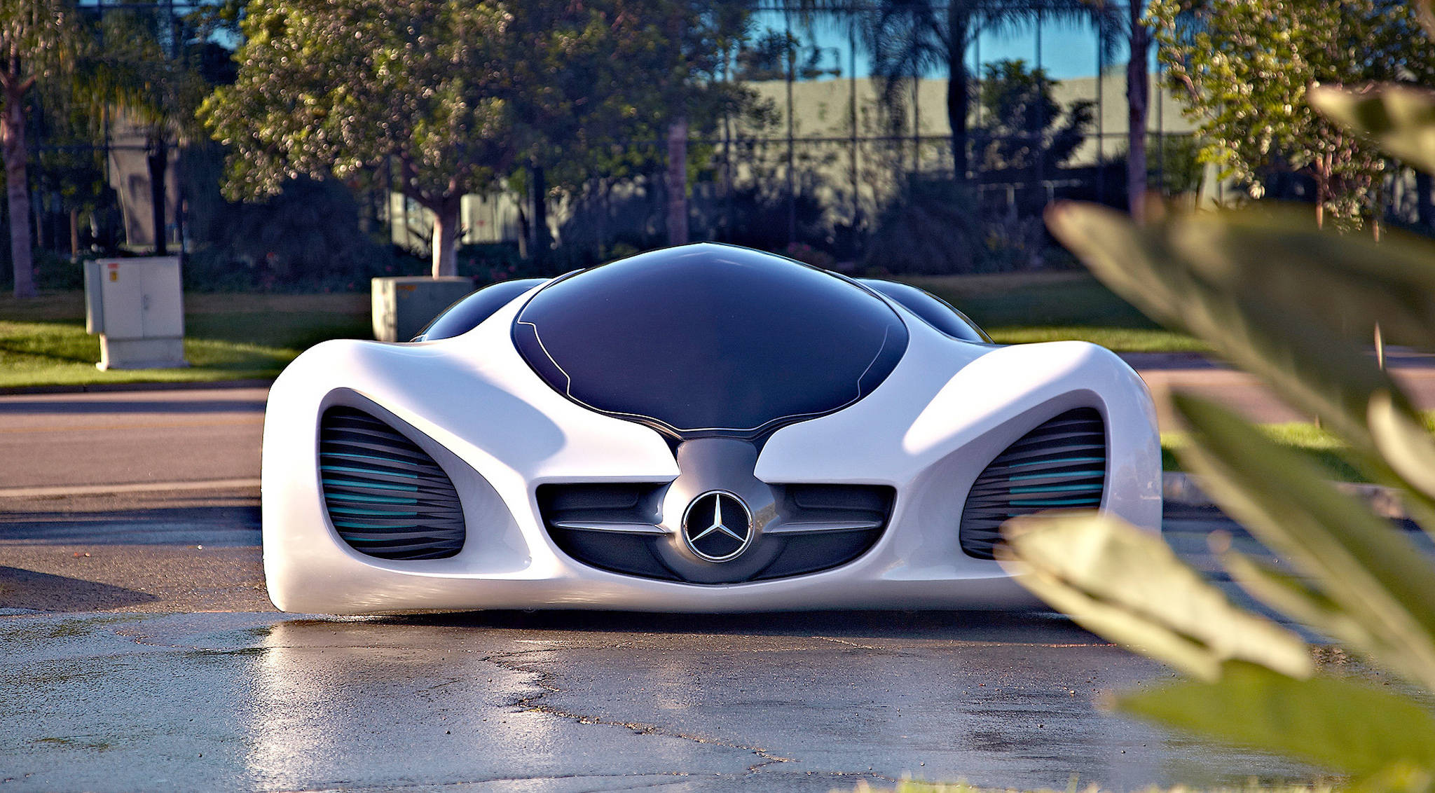 mercedes iPhone 桌布 壁紙 — 一架時尚的白色未來感 Mercedes 跑車，帶有發光的藍色通風口，在明亮的日光下停在濕漉漉的路面上。