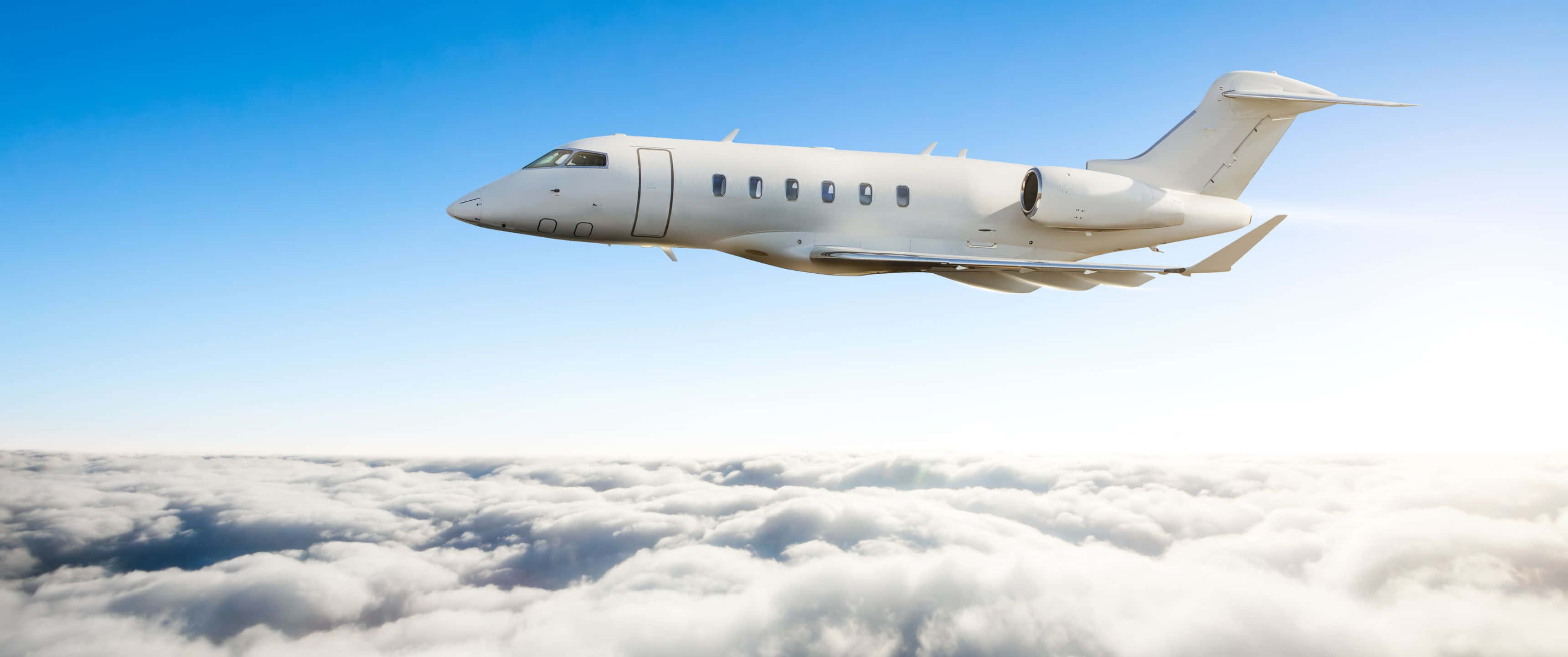 3440x1440p Small Planes 桌布 壁紙 — 一架時尚的白色私人飛機在晴朗的藍天下翱翔於無盡的蓬鬆雲層之上。