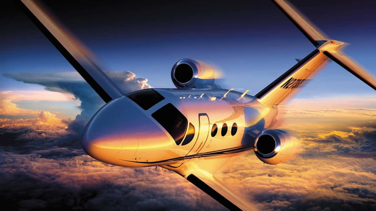 飛機 桌布 壁紙 — 一架時尚的私人飛機在金色雲層上方翱翔，背景是夕陽下充滿活力的藍天。