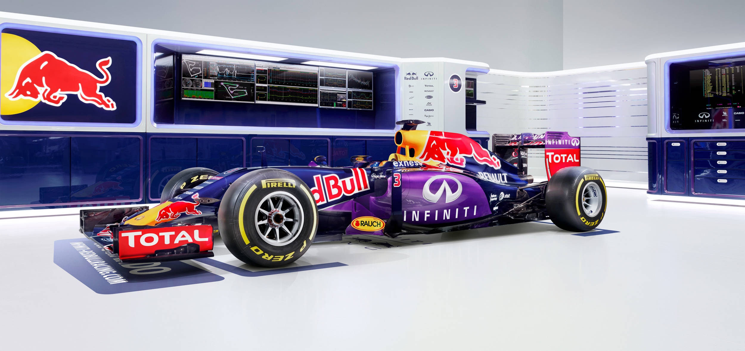 Infiniti 桌布 壁紙 — 一架時尚的紫色紅牛一級方程式賽車，帶有醒目的贊助商標誌，停放在一個配備發光螢幕和品牌標識的高科技車庫中。