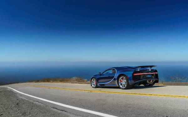 藍色 Bugatti 跑車停泊在沿海公路，享有海景。 — 4K 壁紙
