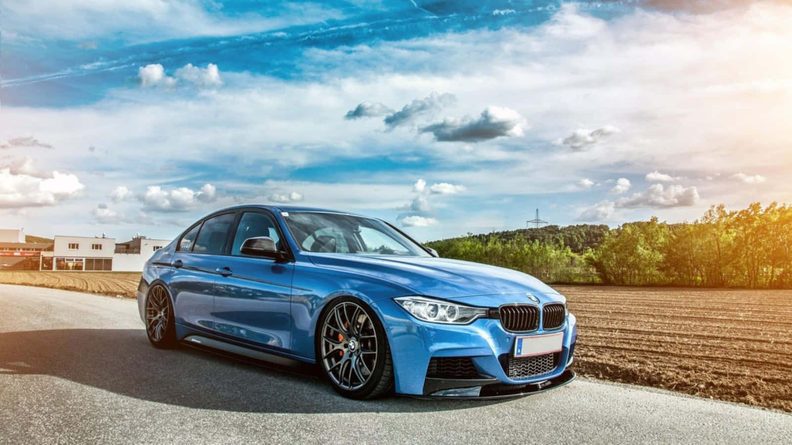 藍色BMW跑車停泊在日落時分的鄉村道路上。 — BMW 動圖 壁紙