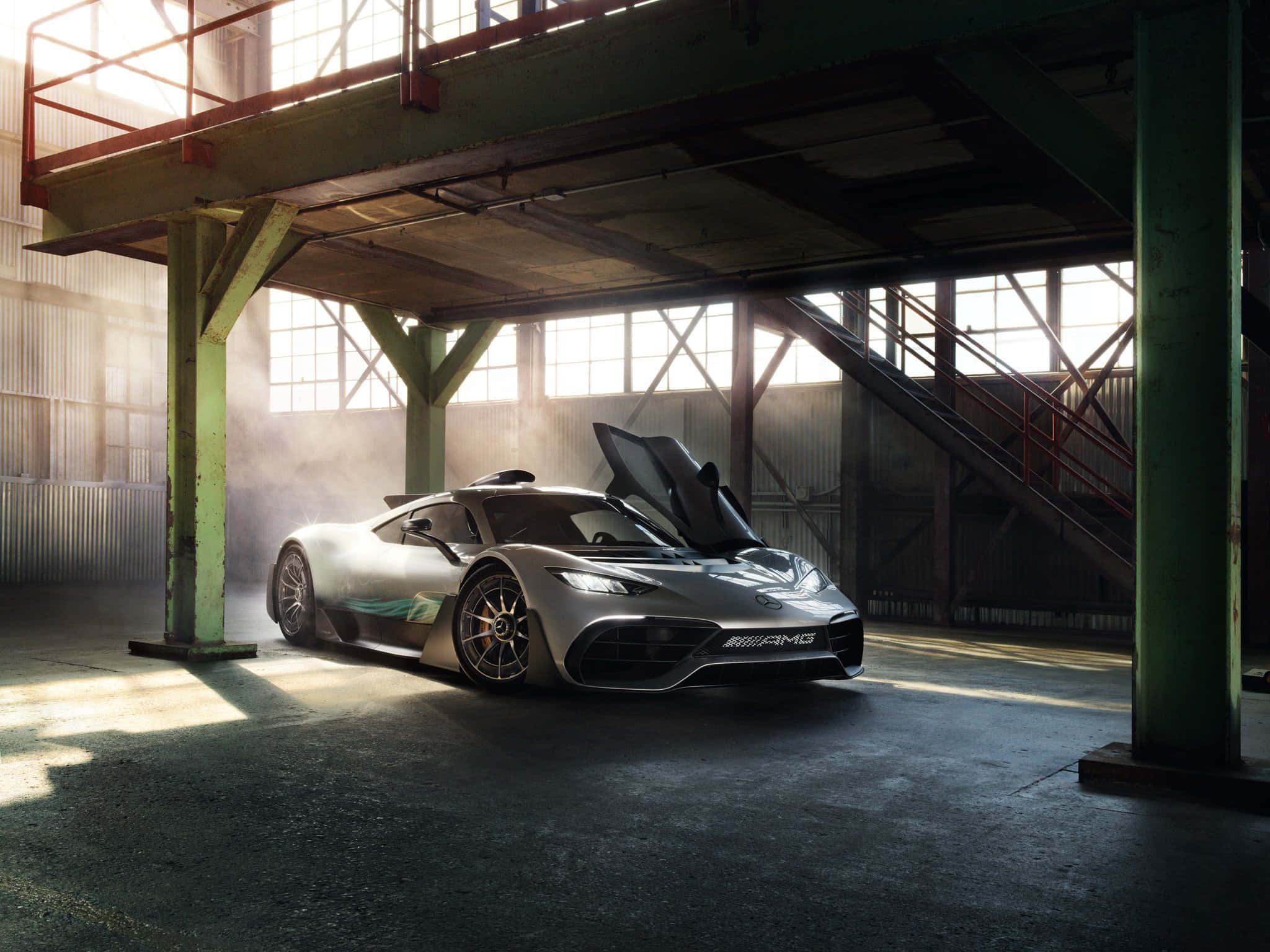 Mercedes 桌布 壁紙 — 一架時尚的銀色 Mercedes-AMG 跑車，打開鷗翼車門，戲劇性地停放在陽光普照的工業倉庫中，灰塵在光束中飄浮。