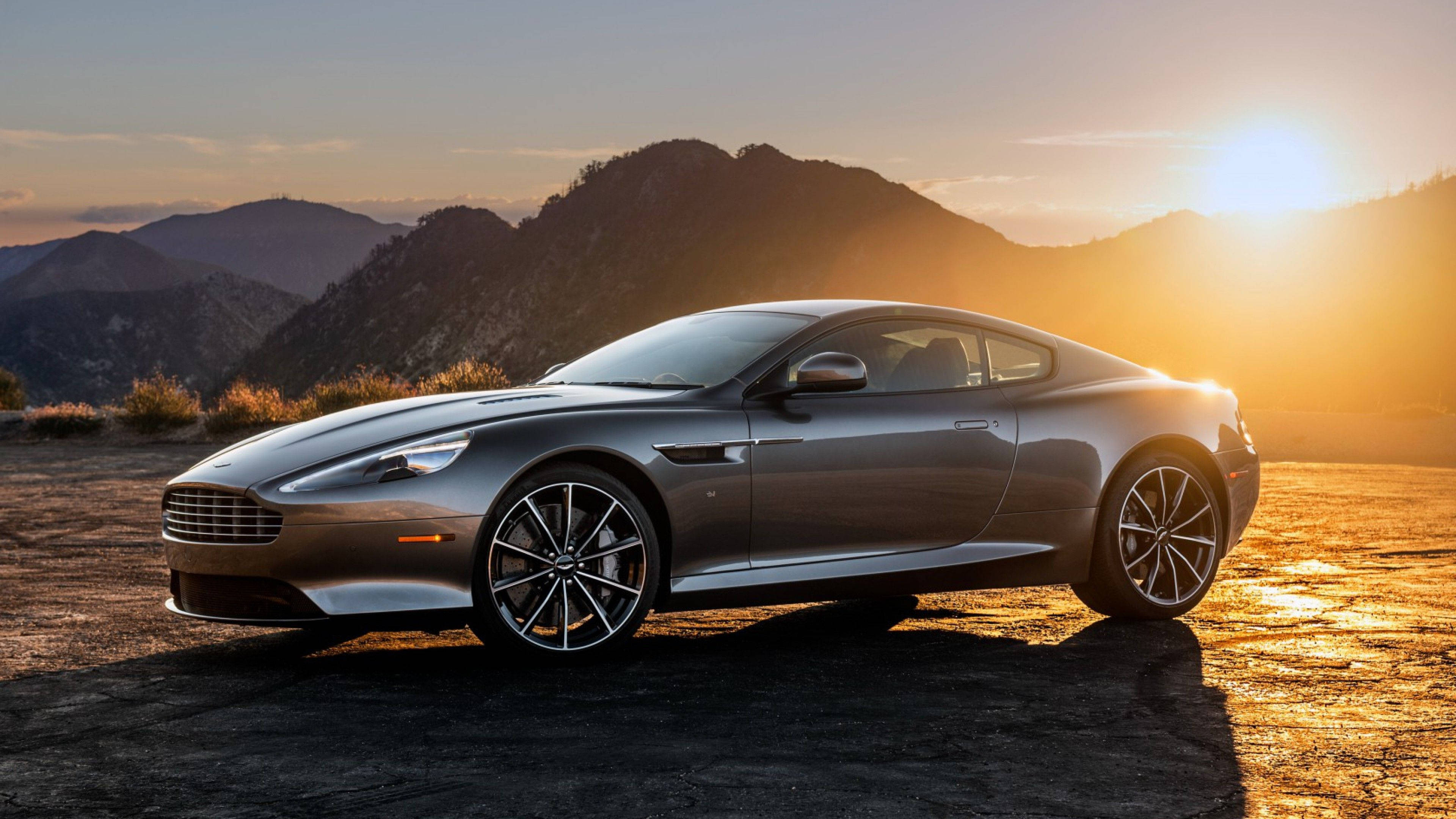 奧斯頓馬丁 桌布 壁紙 — 一架時尚的銀色Aston Martin跑車停在塵土飛揚的山路上，正值金色日落。