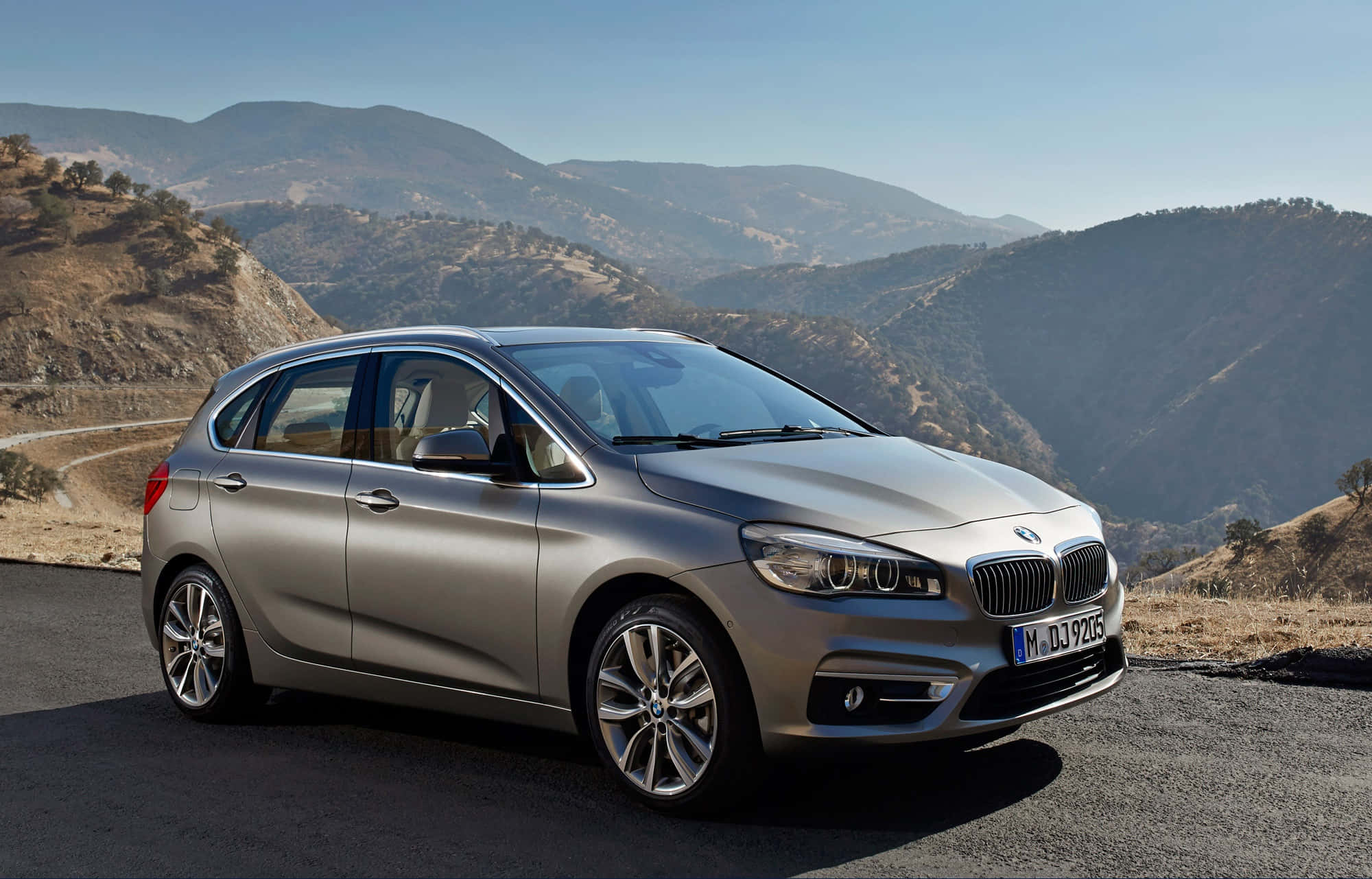 Bmw 2 Series 桌布 壁紙 — 一架時尚的銀色BMW 2系列Active Tourer停泊在蜿蜒的山路上，天空清澈湛藍。