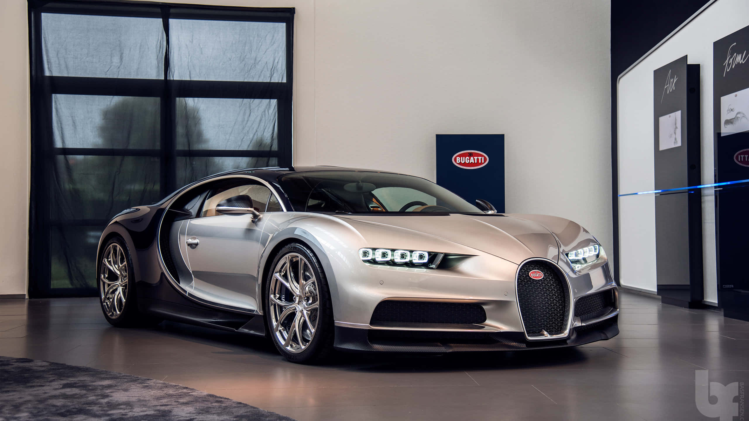 桌布 壁紙 — 一架時尚的銀色Bugatti Chiron，配以打開的鷗翼門，在一個極簡豪華展示間中展示，地板拋光，牆壁帶有品牌標誌。