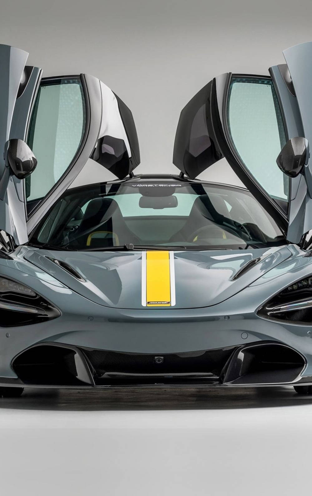 跑車 桌布 壁紙 — 一架時尚的銀色McLaren跑車，鷗翼車門打開，引擎蓋上有一條大膽的黃色條紋。