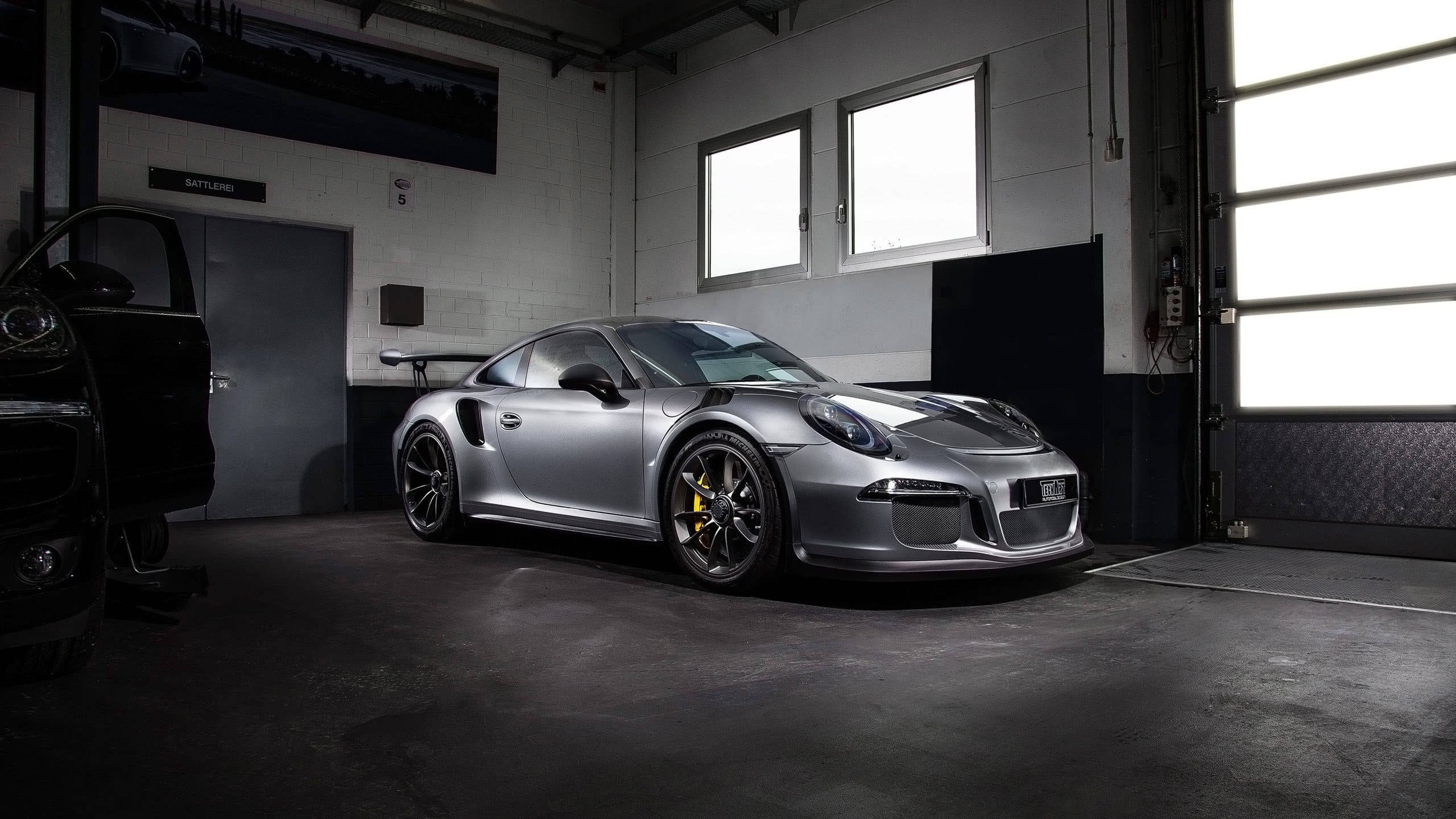 銀色保時捷911 GT2 RS在車庫中，車庫門打開，自然光照射。 — 保時捷 GIF 壁紙