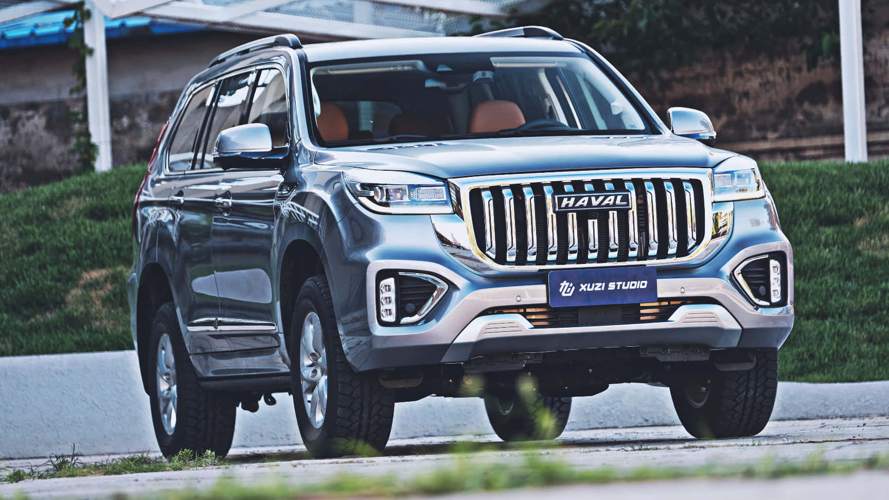 Haval 桌布 壁紙 — 一架時尚的銀色哈弗SUV停泊在鋪砌道路上，背景有綠色草地和混凝土牆。