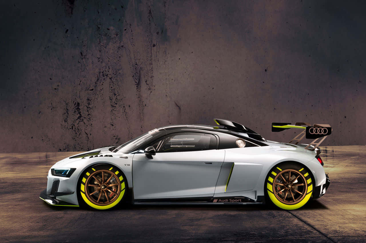 奧迪 桌布 壁紙 — 一架時尚的銀色奧迪R8 LMS GT3賽車，帶有螢光黃色點綴和青銅輪圈，停在紋理混凝土牆前。