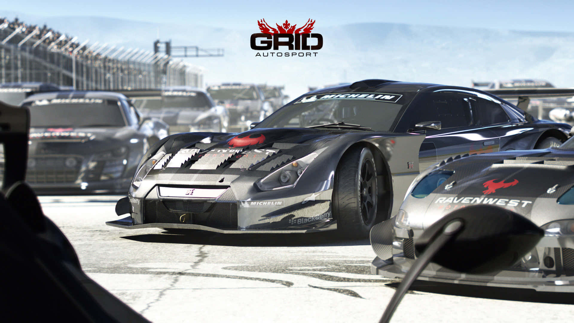 1080p Grid Autosport 桌布 壁紙 — 一架時尚的銀色賽車，帶有黑色飾邊和贊助商標誌，在陽光明媚的賽道上奔馳，背景有其他車輛。