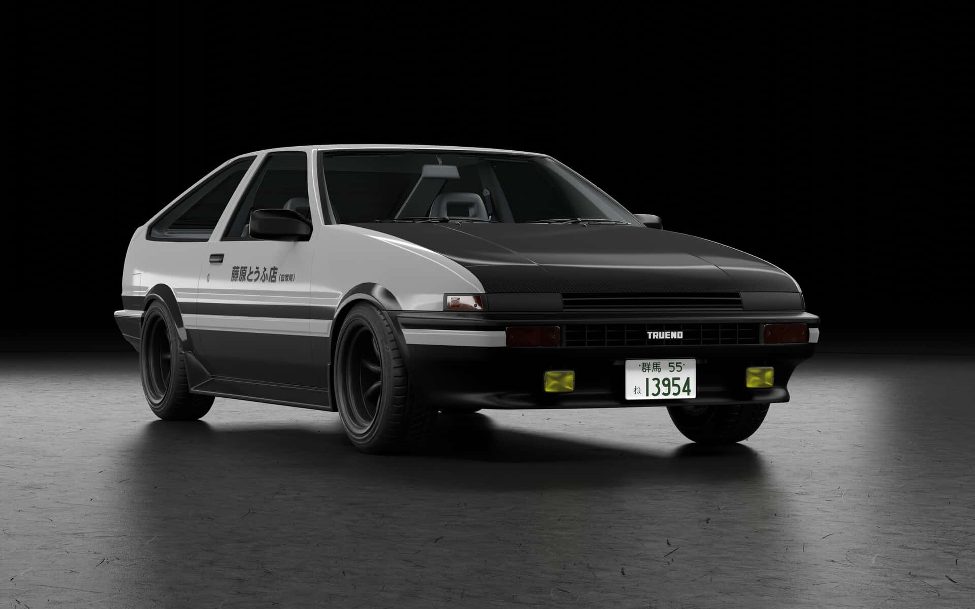 桌布 壁紙 — 一架時尚的黑白豐田AE86跑車，帶有日文字和黃色頭燈，在黑暗的攝影棚地板上戲劇性地照亮。