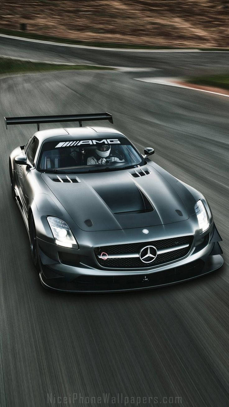 amg iPhone 桌布 壁紙 — 一架時尚的黑色 Mercedes-AMG GT 賽車在蜿蜒的瀝青賽道上飛馳，動態模糊效果凸顯其速度。