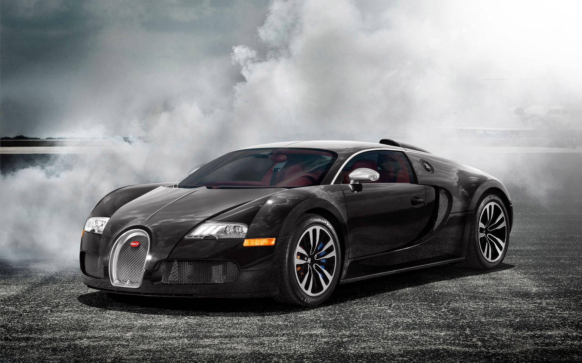 Cool Bugatti 桌布 壁紙 — 一架時尚的黑色Bugatti Veyron在暴風雨天空下的潮濕瀝青賽道上冒煙飄移。