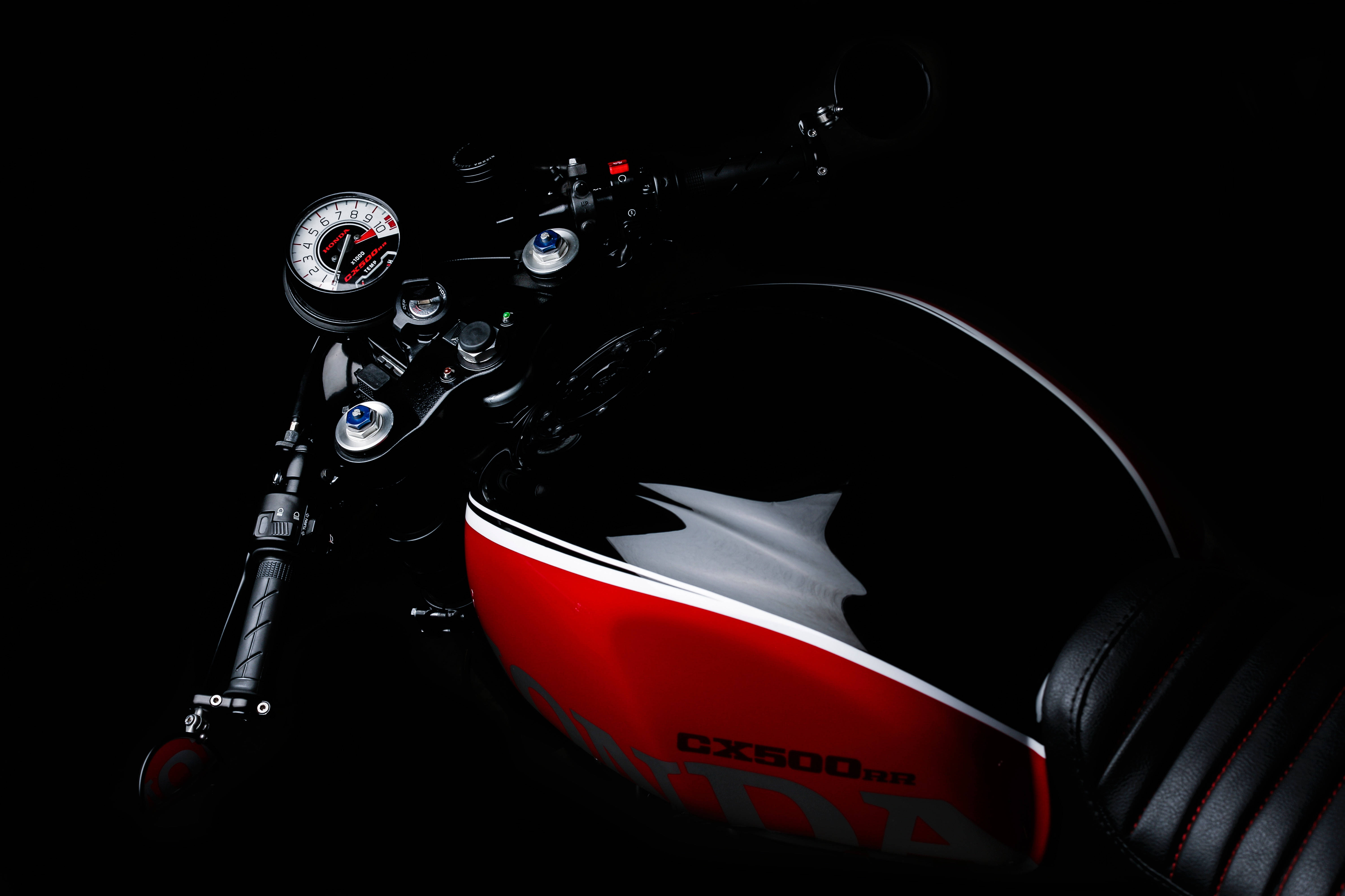 機車 桌布 壁紙 — 一架時尚的黑色和紅色本田 CX500RB 摩托車在純黑色背景下，在戲劇性的工作室燈光下閃閃發光。