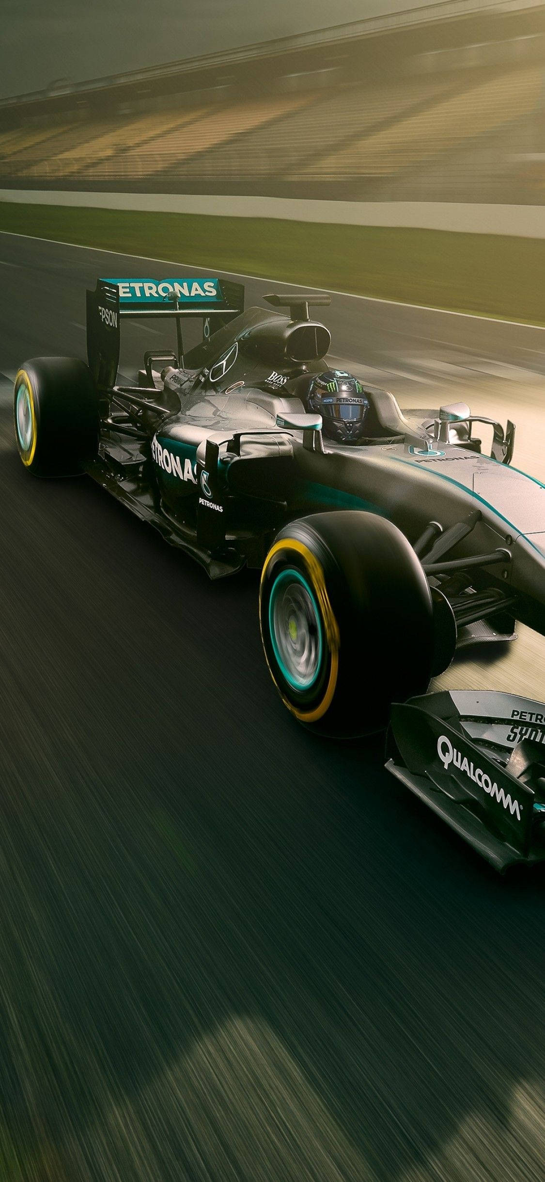 F1 iPhone 壁紙 桌布 壁紙 — 一架時尚的黑色和藍綠色一級方程式賽車沿著賽道飛馳，動態模糊傳達出高速感。