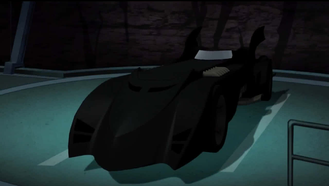 Batcave 桌布 壁紙 — 一架時尚的黑色蝙蝠車停泊在燈光昏暗的車庫中，青綠色的地板燈光投射出銳利的陰影。
