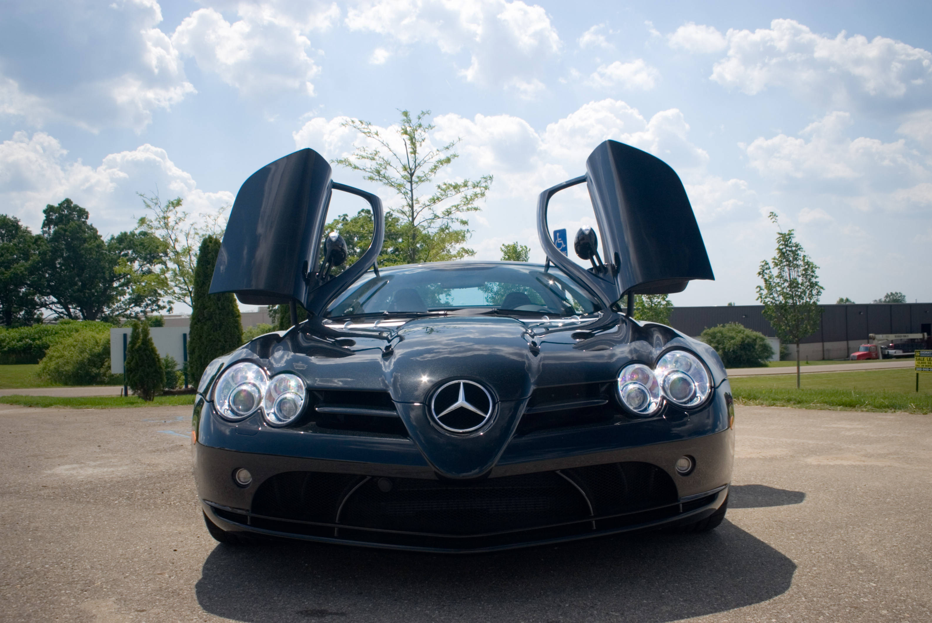 高畫質 賓士 桌布 壁紙 — 一架時尚的黑色賓士 SLR McLaren，鷗翼門打開，在明亮的陰天下。