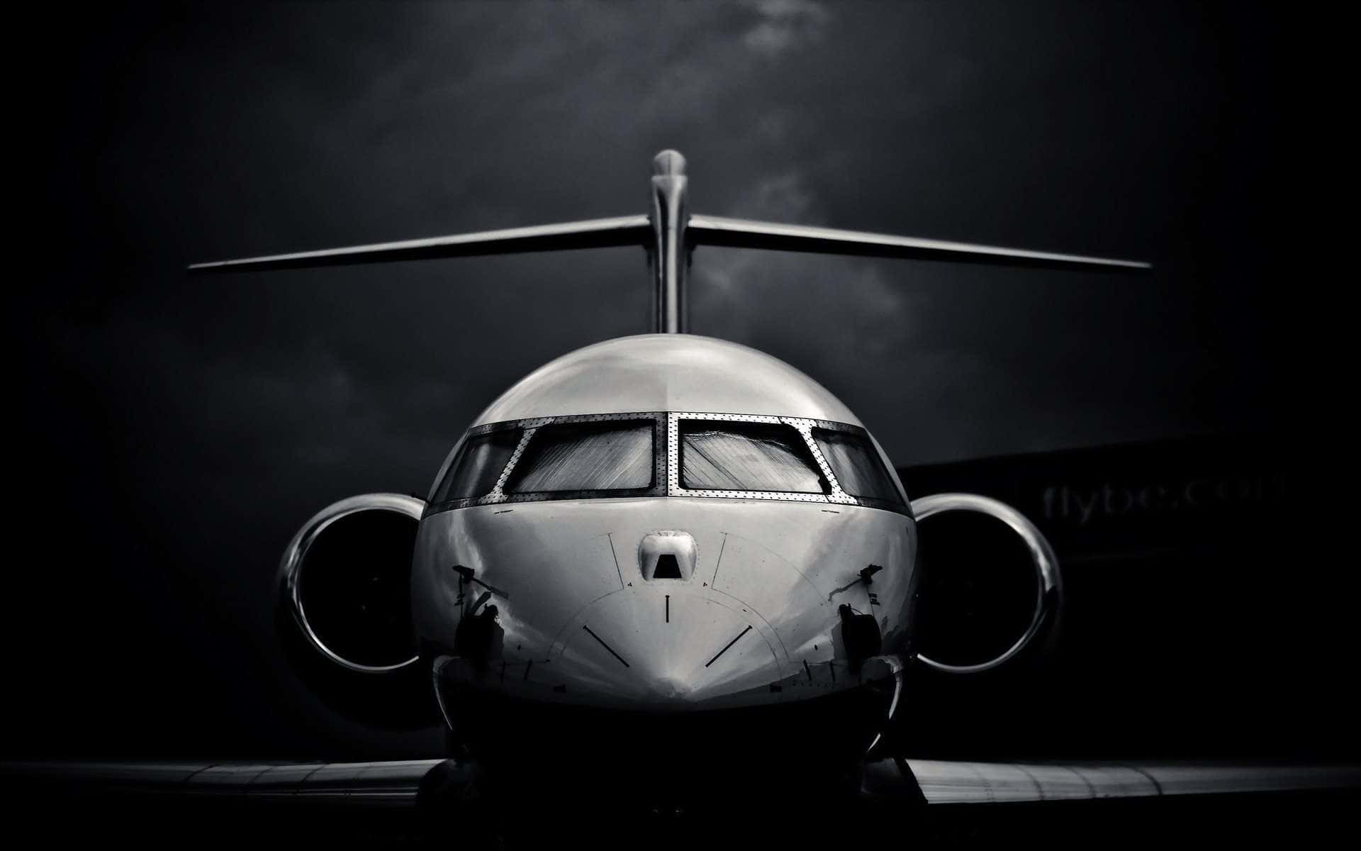 Aviation 桌布 壁紙 — 一架時尚私人飛機在戲劇性的烏雲下向前，呈現高對比度的黑白照片。