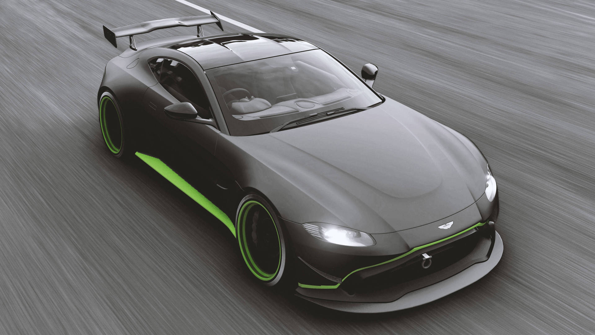 電玩遊戲 桌布 壁紙 — 一架時尚黑色Aston Martin跑車，帶有鮮綠色點綴，在模糊的賽道表面上疾馳。