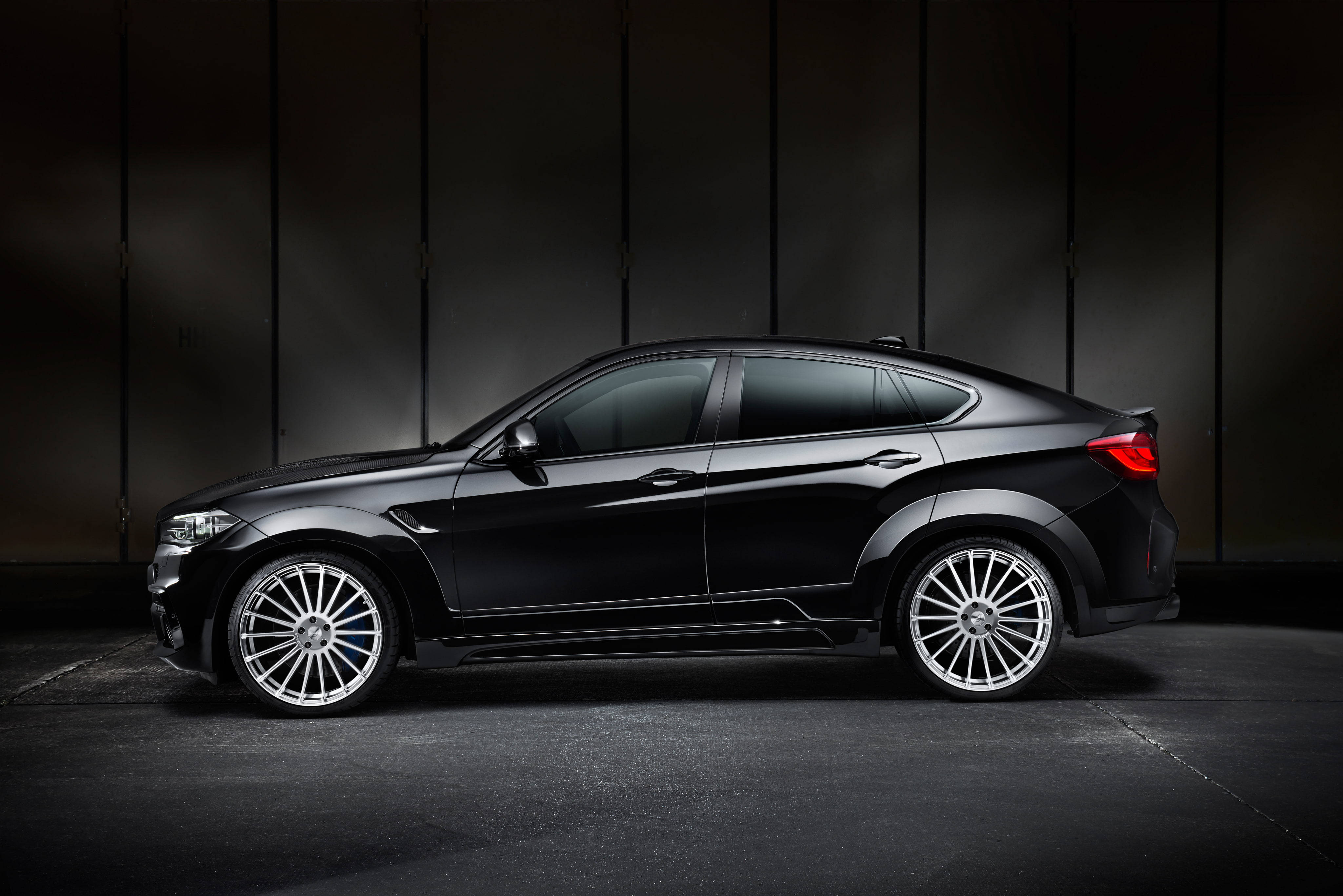 m 桌布 壁紙 — 一架時尚黑色BMW X6M運動轎跑車配銀色輪圈，矗立在帶有垂直鑲板的昏暗工作室中。