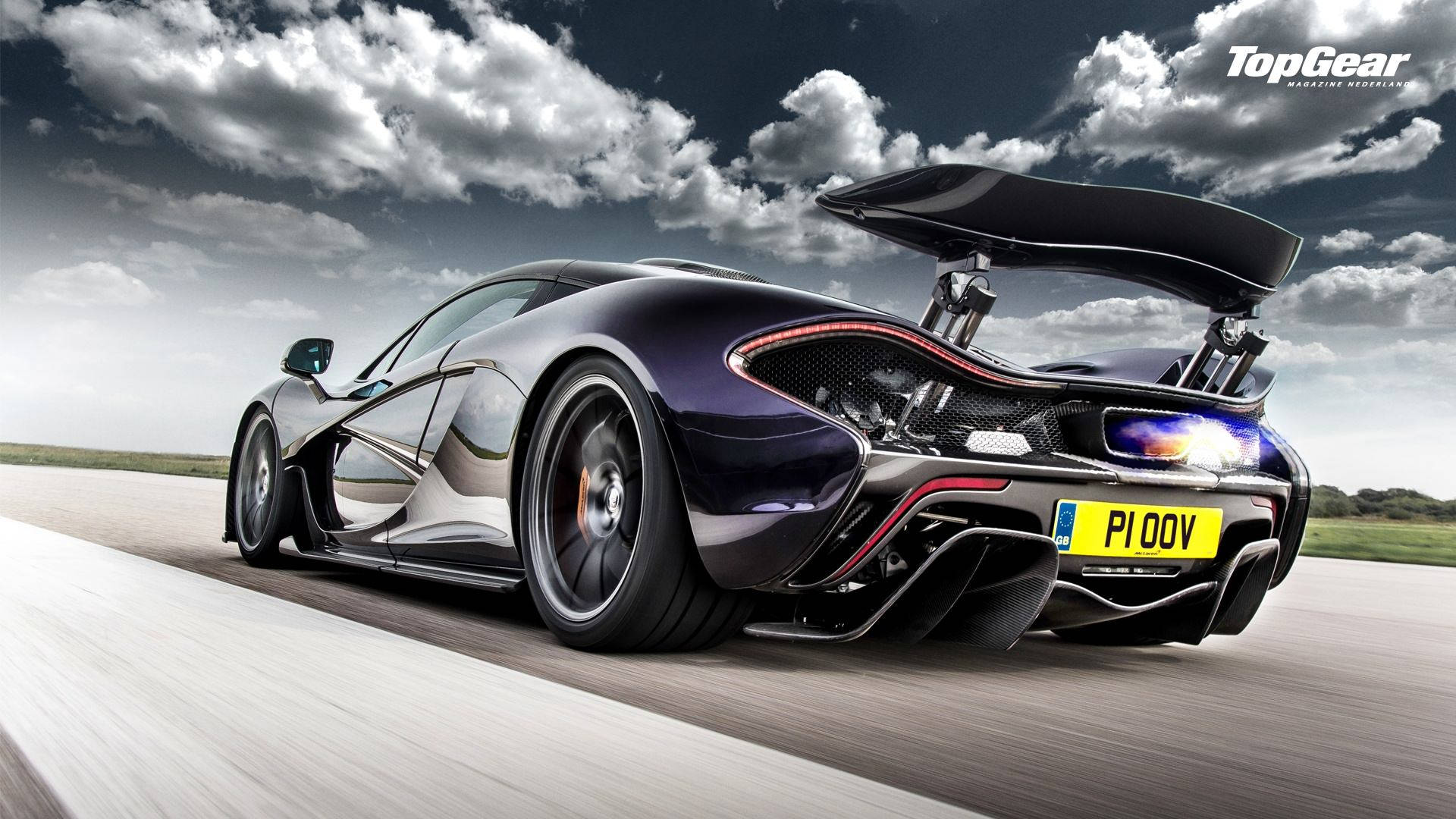 麥拉倫 桌布 壁紙 — 一架時尚黑色McLaren P1超級跑車在戲劇性的多雲天空下於跑道上高速飛馳，尾翼升起。