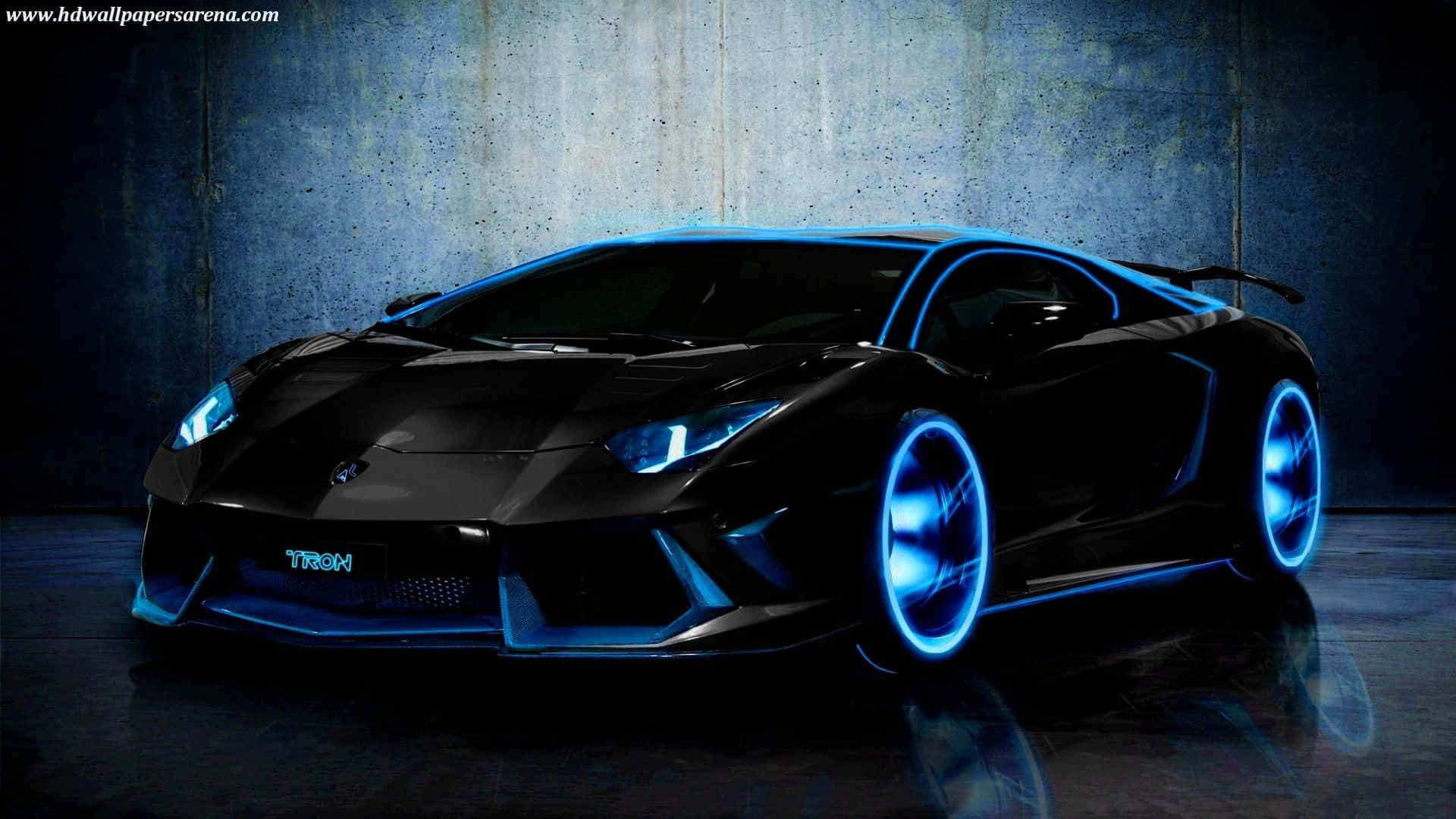 1920 X 1080 Car 桌布 壁紙 — 一架時尚黑色藍寶堅尼Aventador，車輪和車頭燈帶有發光藍色霓虹點綴，在深色混凝土牆前展現出戲劇性的姿態。