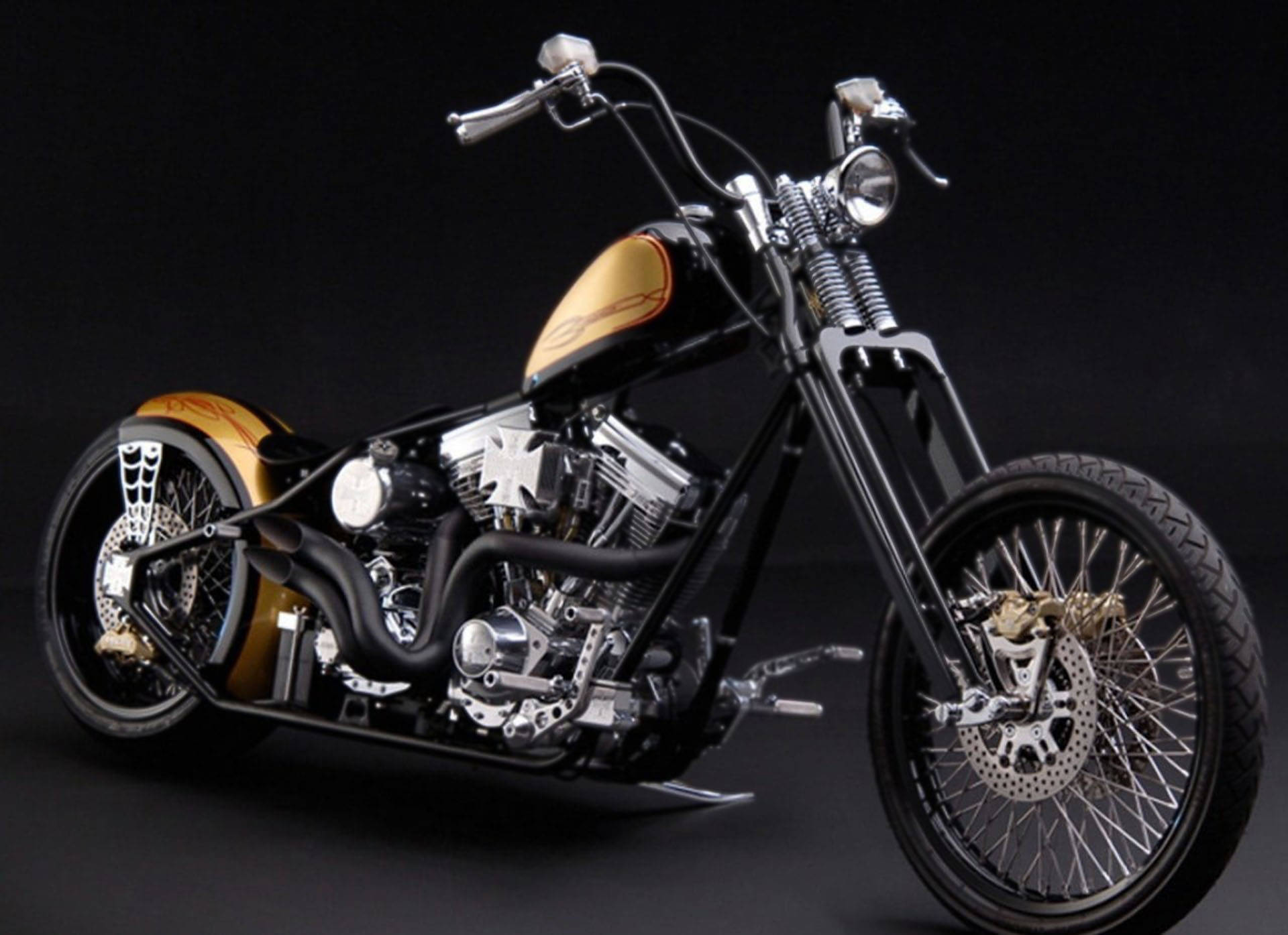 Choppers 桌布 壁紙 — 一架時尚黑色訂製chopper機車，帶有金色火焰裝飾和鍍鉻細節，在黑暗的攝影棚背景下蓄勢待發。