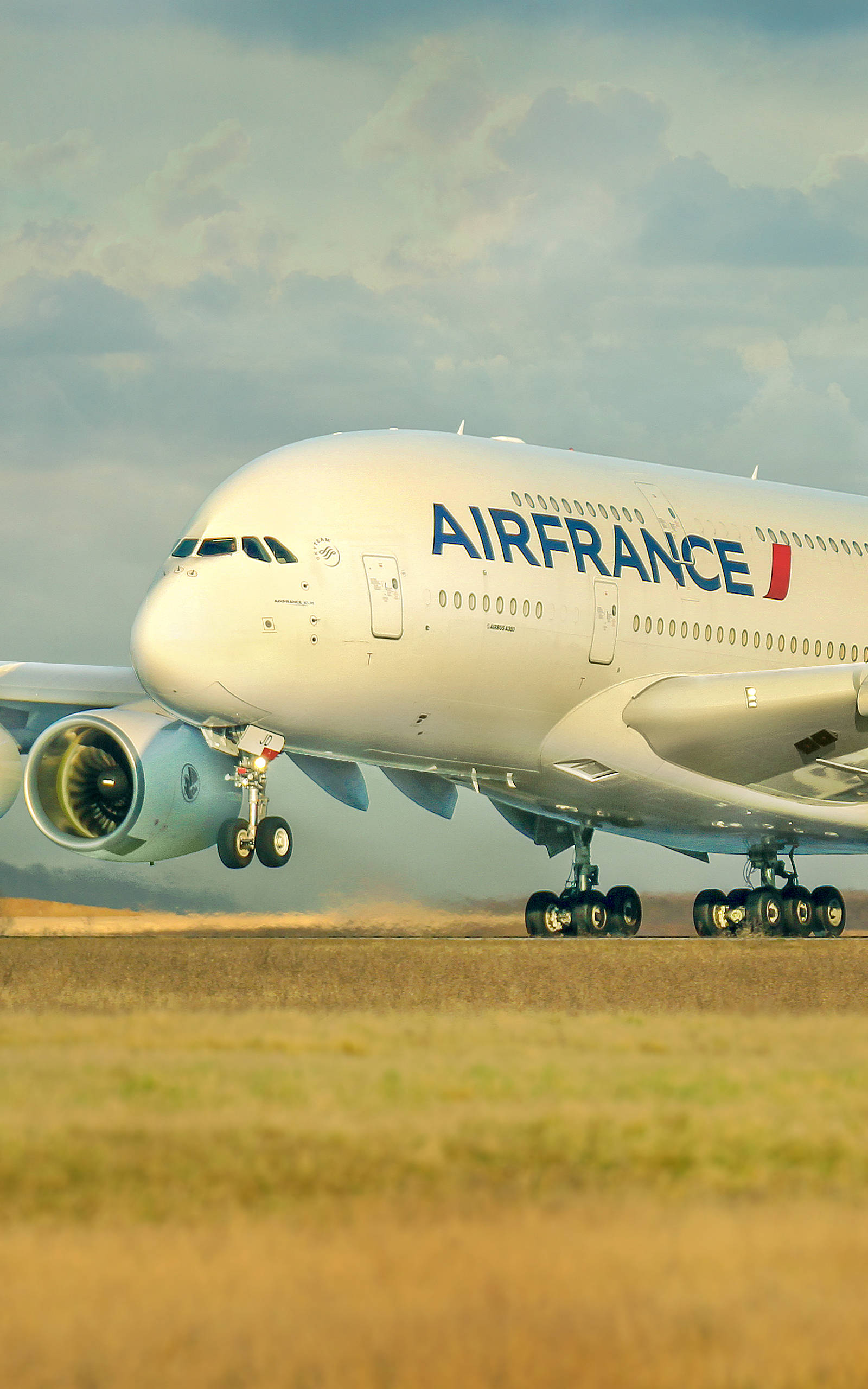 Plane 桌布 壁紙 — 一架法國航空的空中巴士A380在跑道上滑行，背景是金色的草地和多雲的天空。