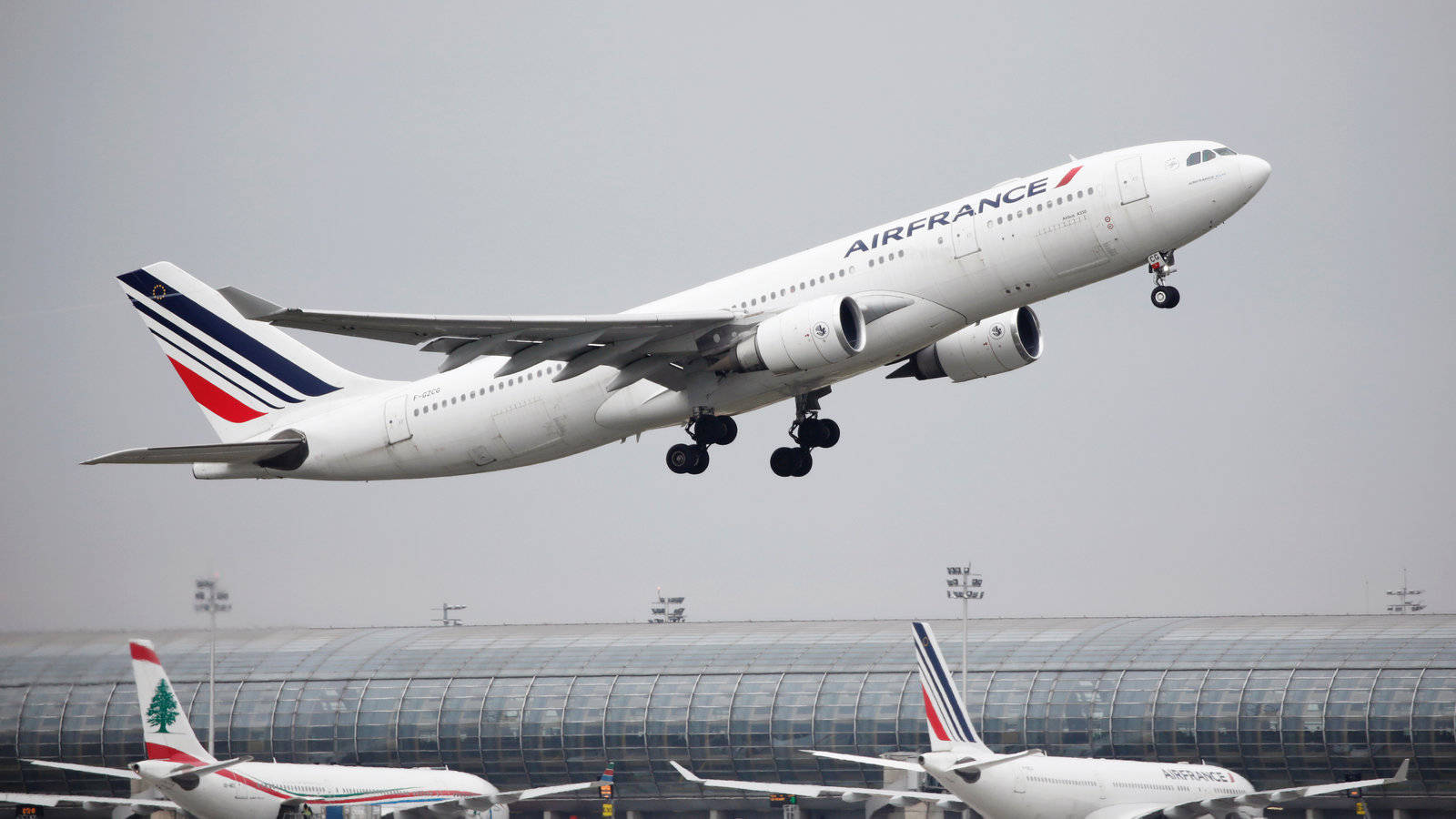 Plane 桌布 壁紙 — 一架法國航空空中巴士A330在灰色天空下，起落架放下，從機場航廈上方起飛。