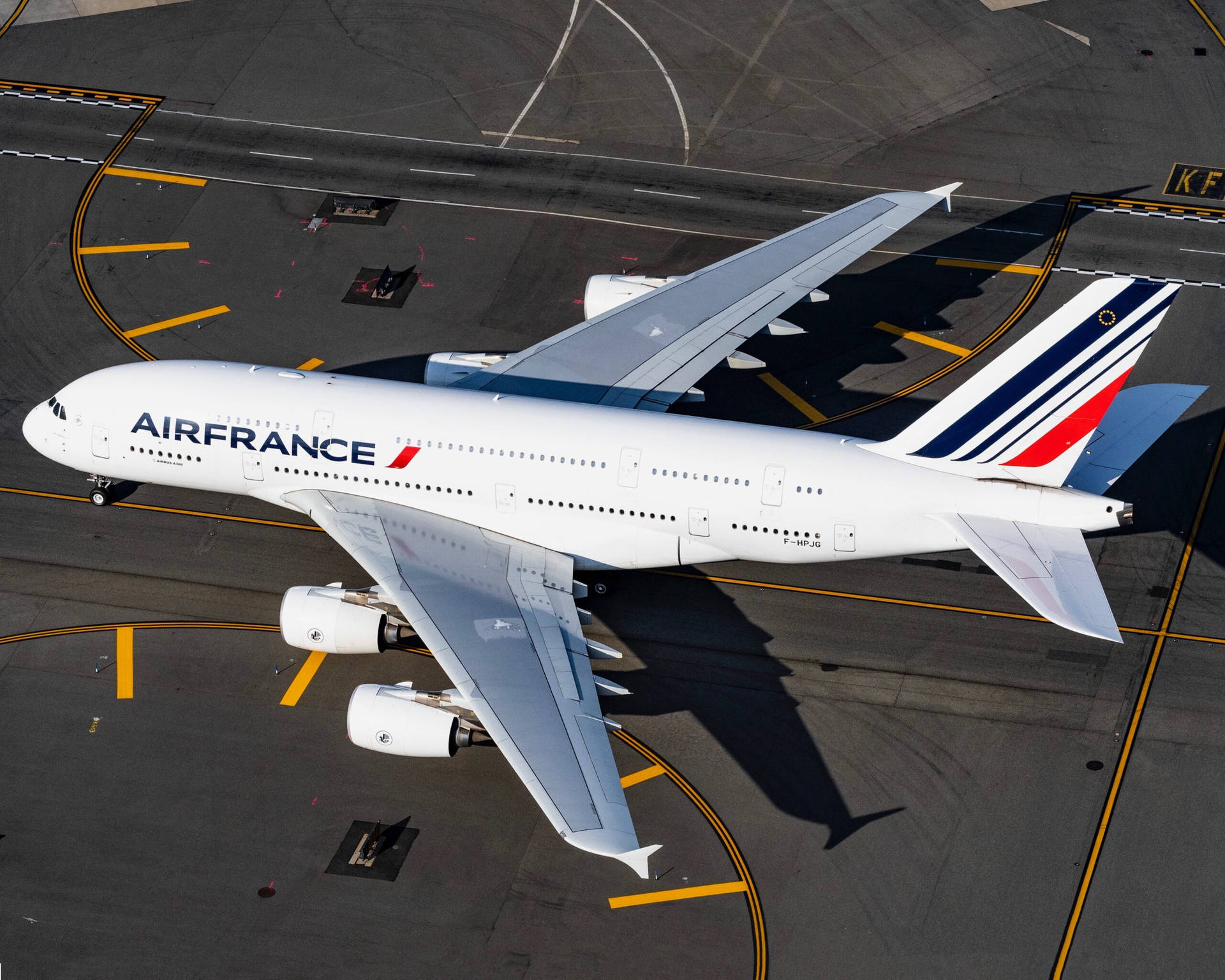  壁紙 — 一架法國航空空中巴士A380在陽光明媚的機場停機坪上滑行，投下長長的影子。