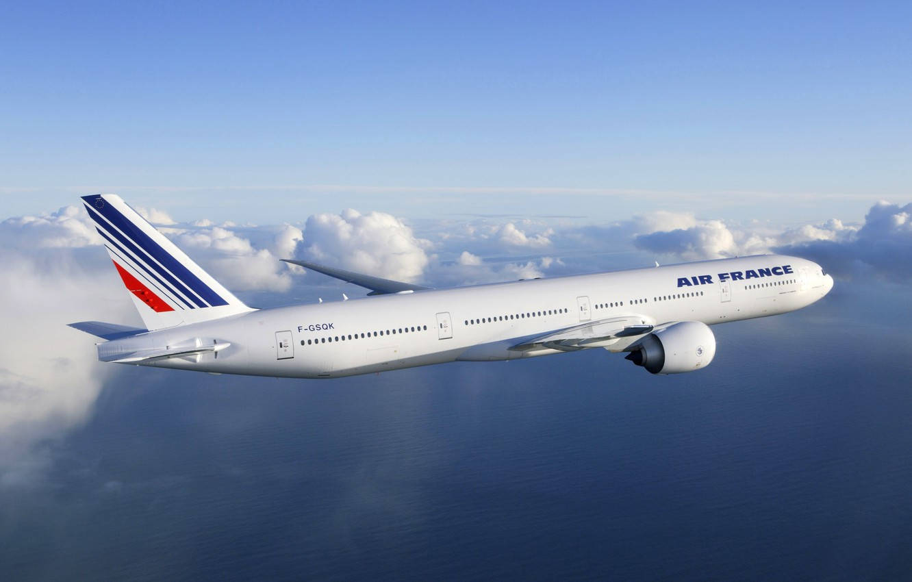 Plane 桌布 壁紙 — 一架法國航空空中巴士在晴朗的天空下，在廣闊的藍色海洋上，平穩地滑翔在蓬鬆的白雲之上。