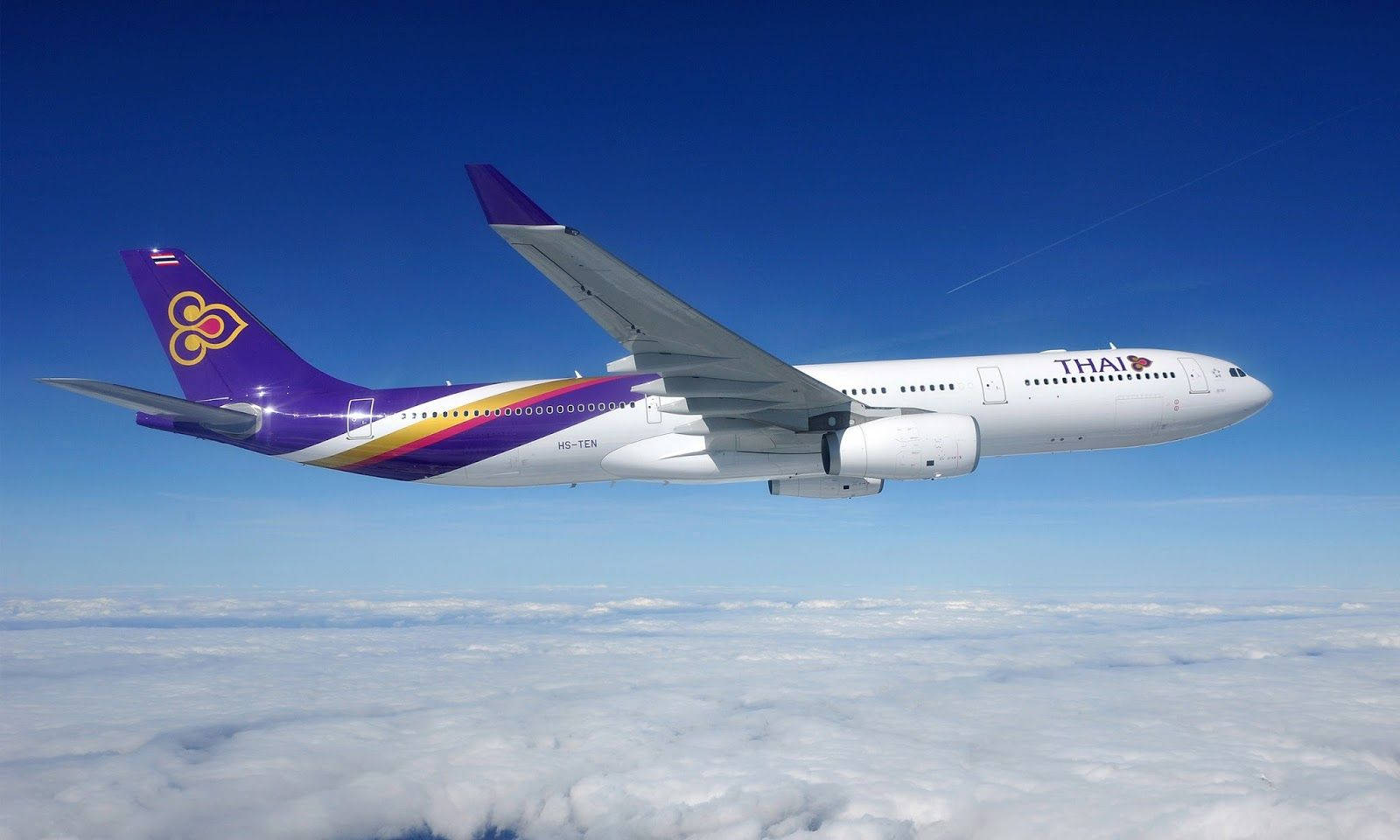 飛機 桌布 壁紙 — 一架泰國航空空中巴士在清澈藍天下平穩滑翔於蓬鬆白雲之上。