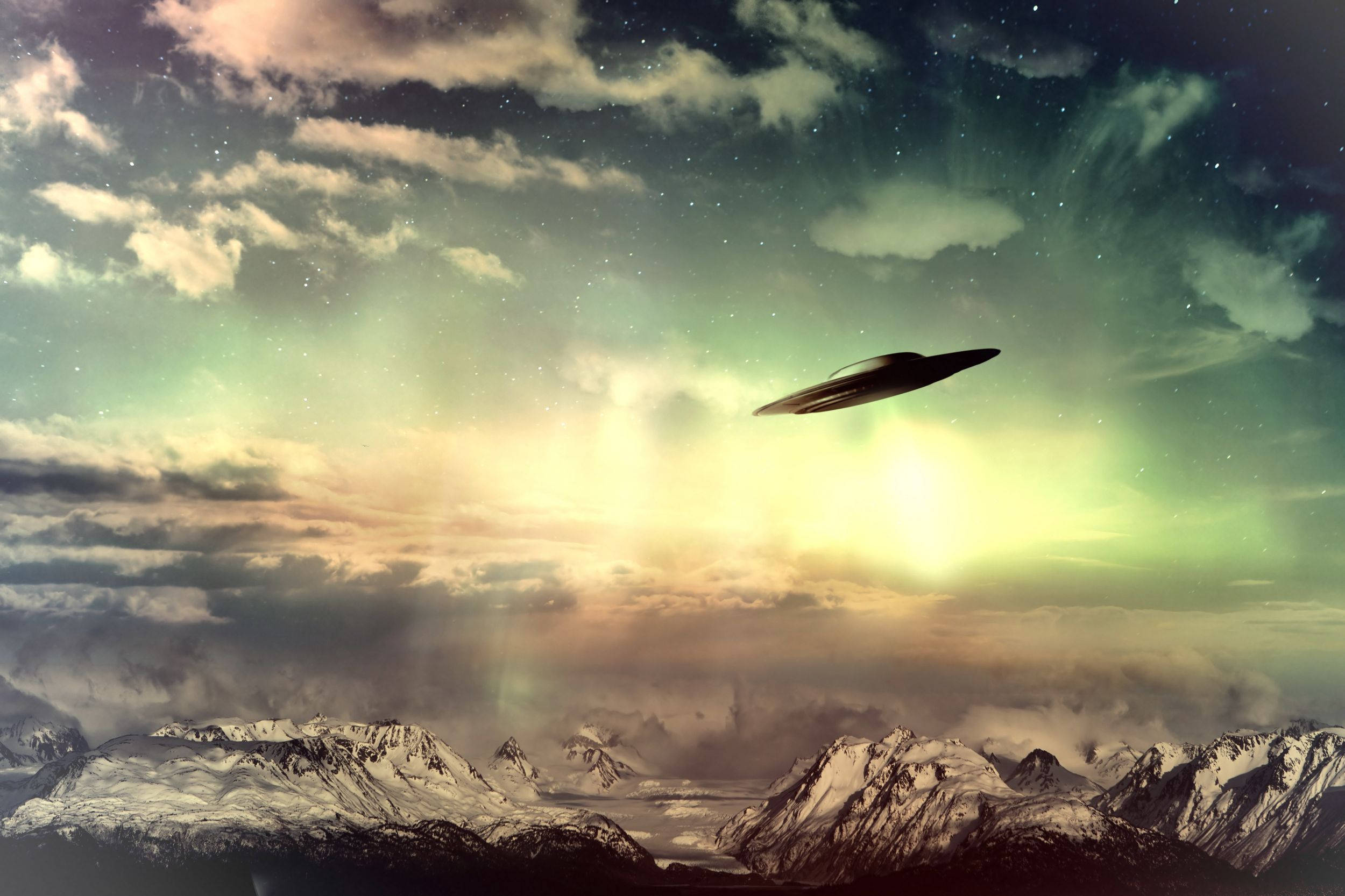 幽浮 桌布 壁紙 — 一架流線型UFO在星光閃爍、極光輝映和柔雲點綴的夜空下，滑翔於積雪的山峰之上。