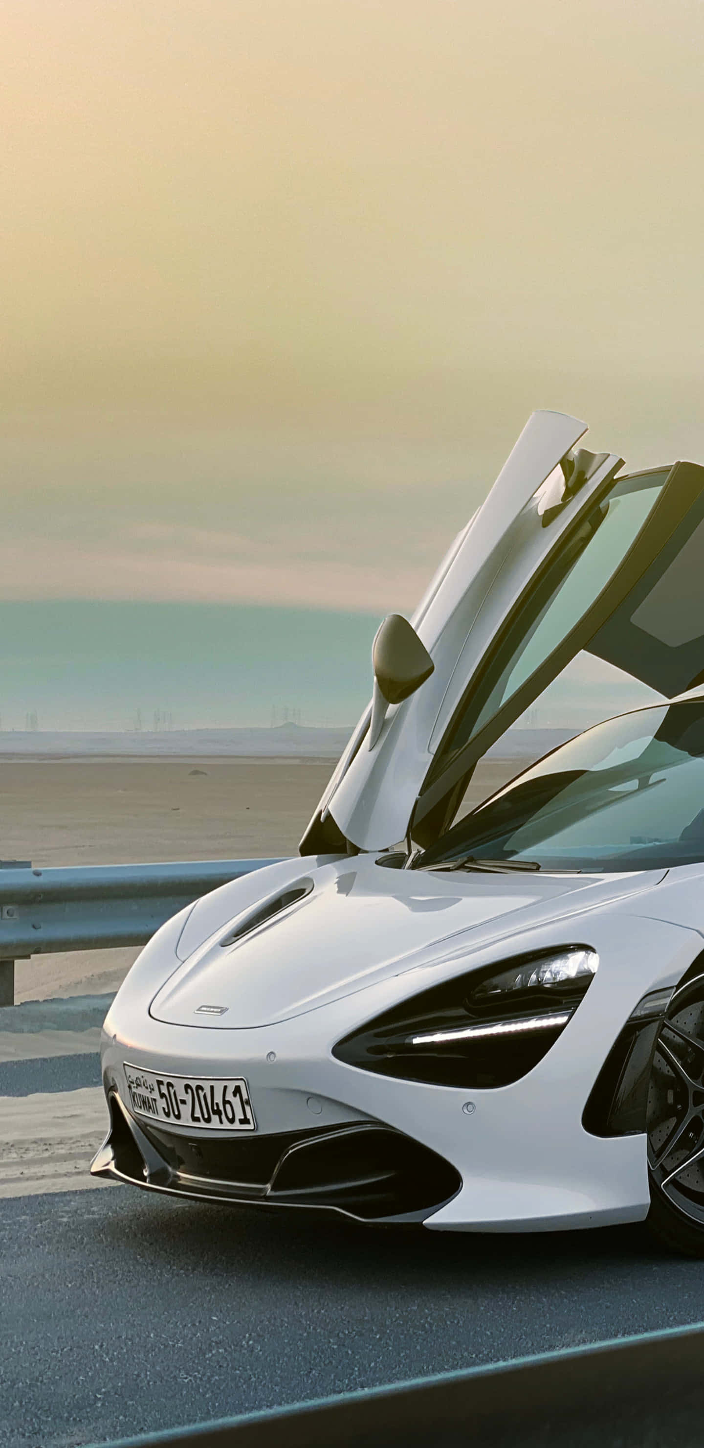 跑車 桌布 壁紙 — 一架流線型白色McLaren跑車，在黃金時段的海岸公路上打開鷗翼車門。