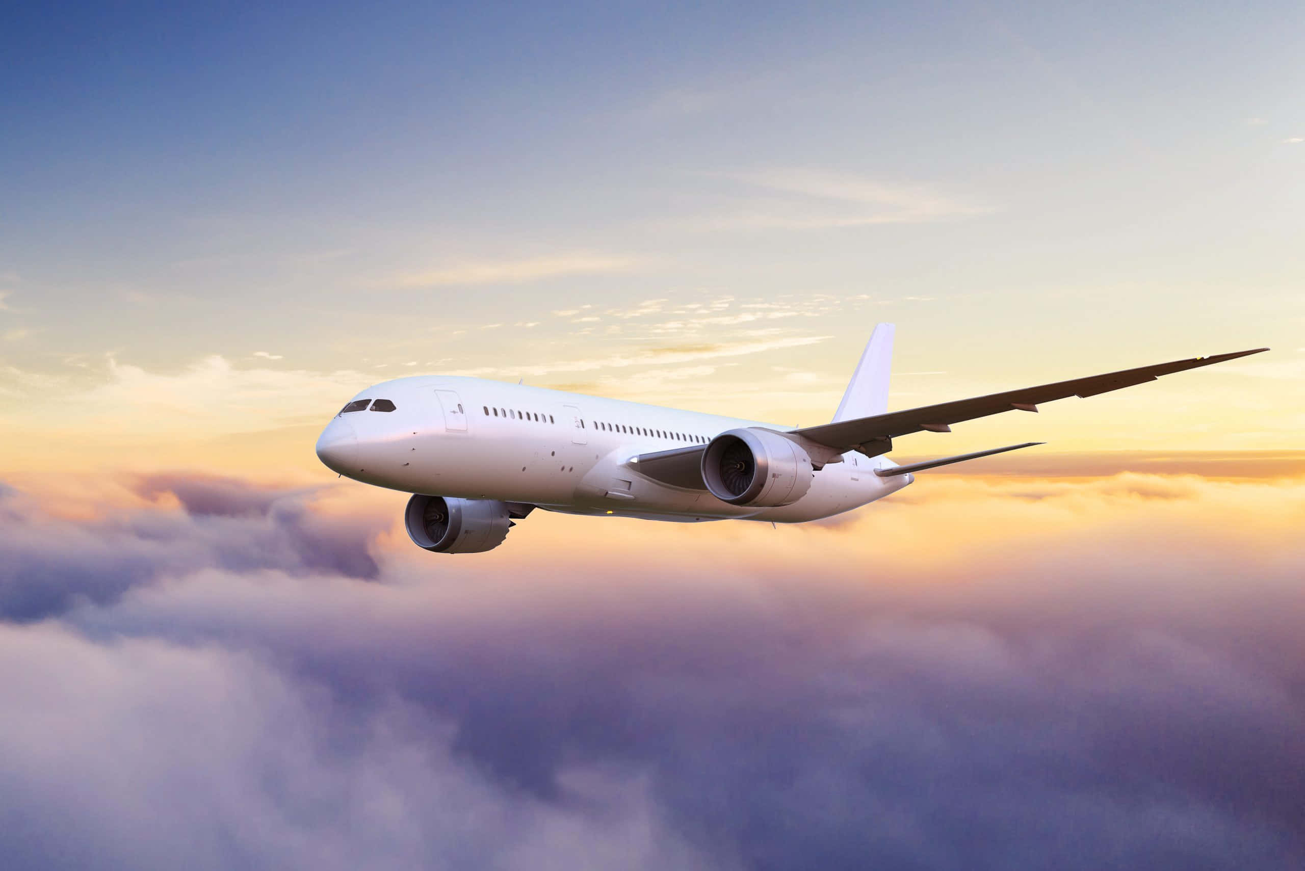飛機 桌布 壁紙 — 一架流線型白色客機在沐浴著金色夕陽的雲海上翱翔。