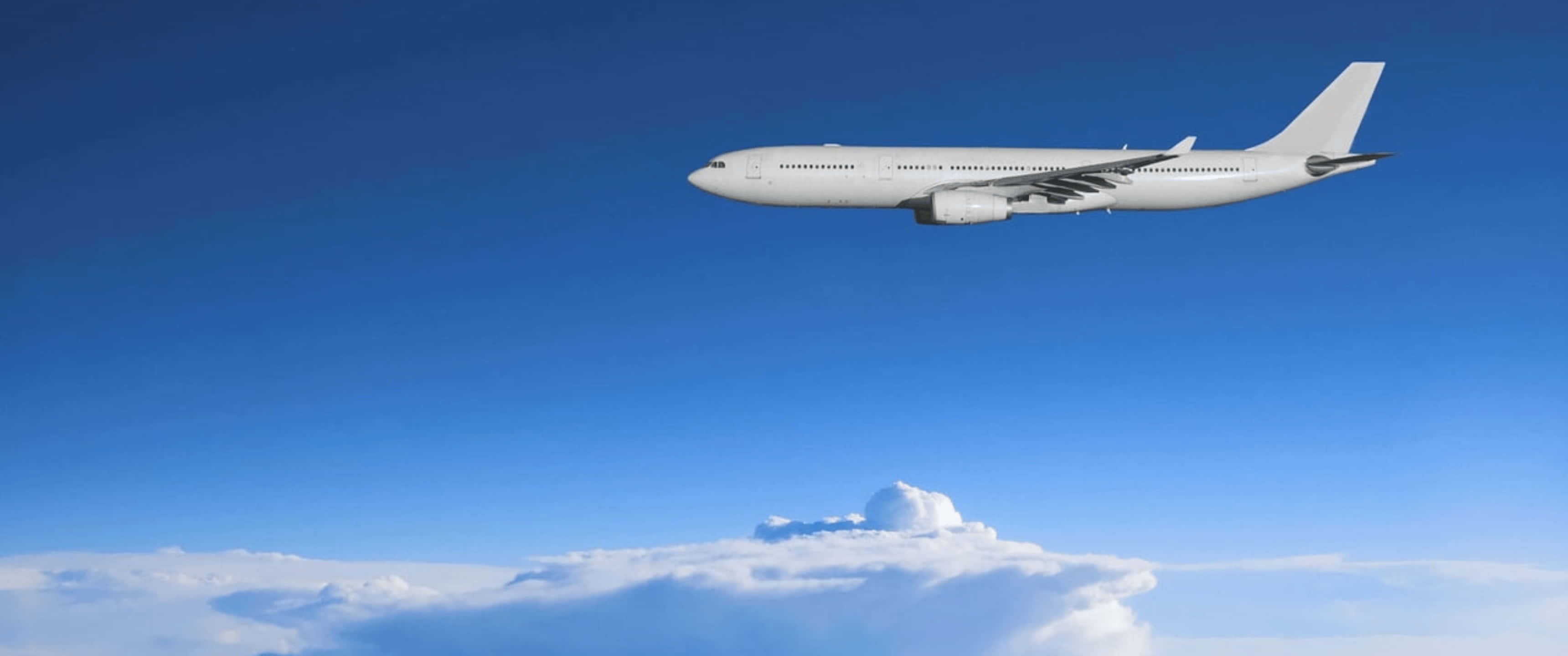 Airbus 桌布 壁紙 — 一架流線型白色客機在清澈藍天中翱翔於蓬鬆白雲之上。