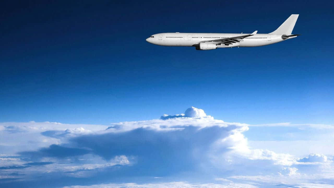 720p Plane 桌布 壁紙 — 一架流線型白色客機在湛藍天空襯托下翱翔於蓬鬆白雲之上。