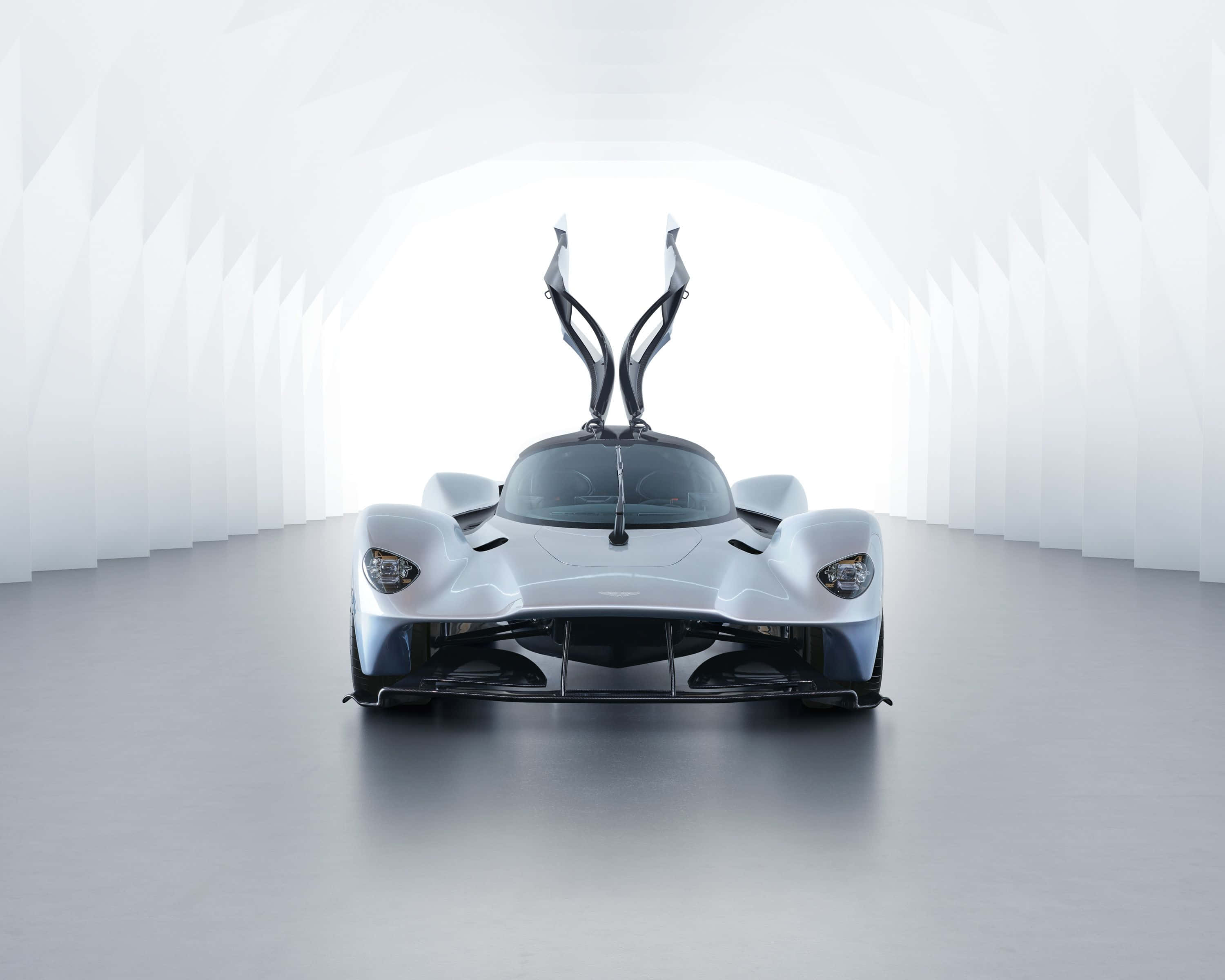 Aston Martin Valkyrie 桌布 壁紙 — 一架流線型白色超跑配鷗翼門，置於簡約白色幾何隧道中央。