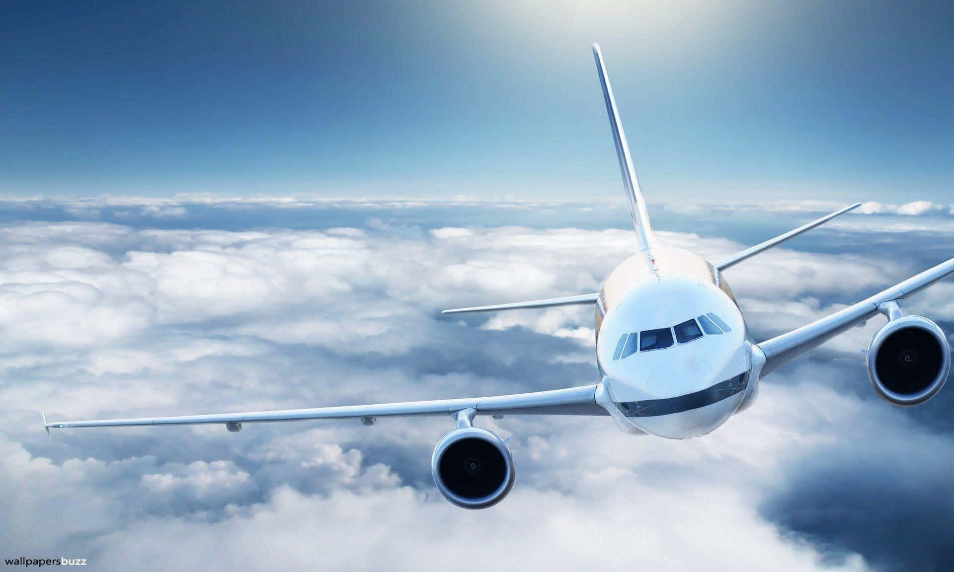Flight 桌布 壁紙 — 一架流線型白色飛機在晴朗藍天和明亮陽光下翱翔於無盡的蓬鬆雲層之上。