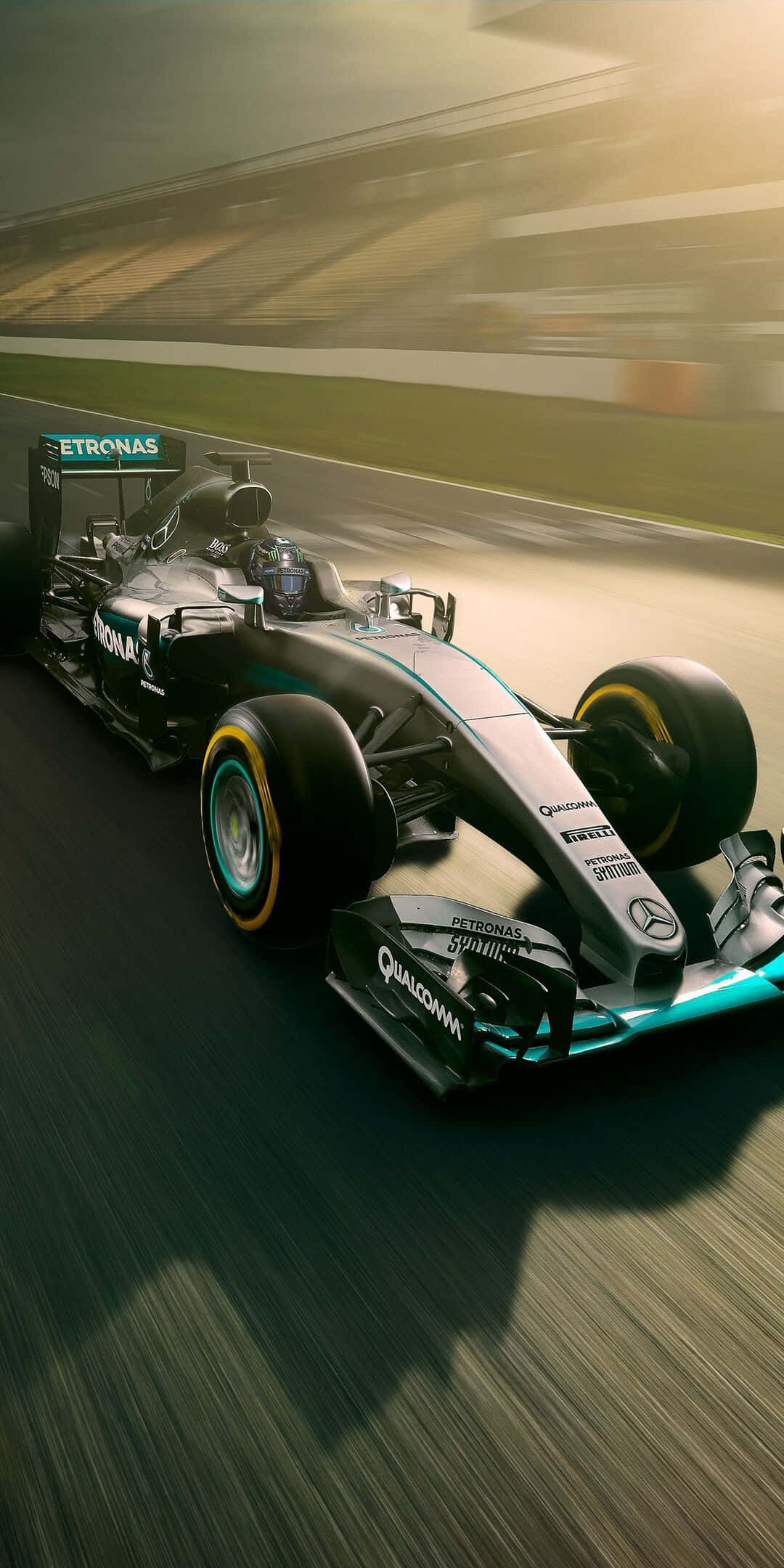 F1 2016 桌布 壁紙 — 一架流線型的銀色和藍綠色一級方程式賽車在賽道上高速飛馳，帶有動態模糊和金色陽光。