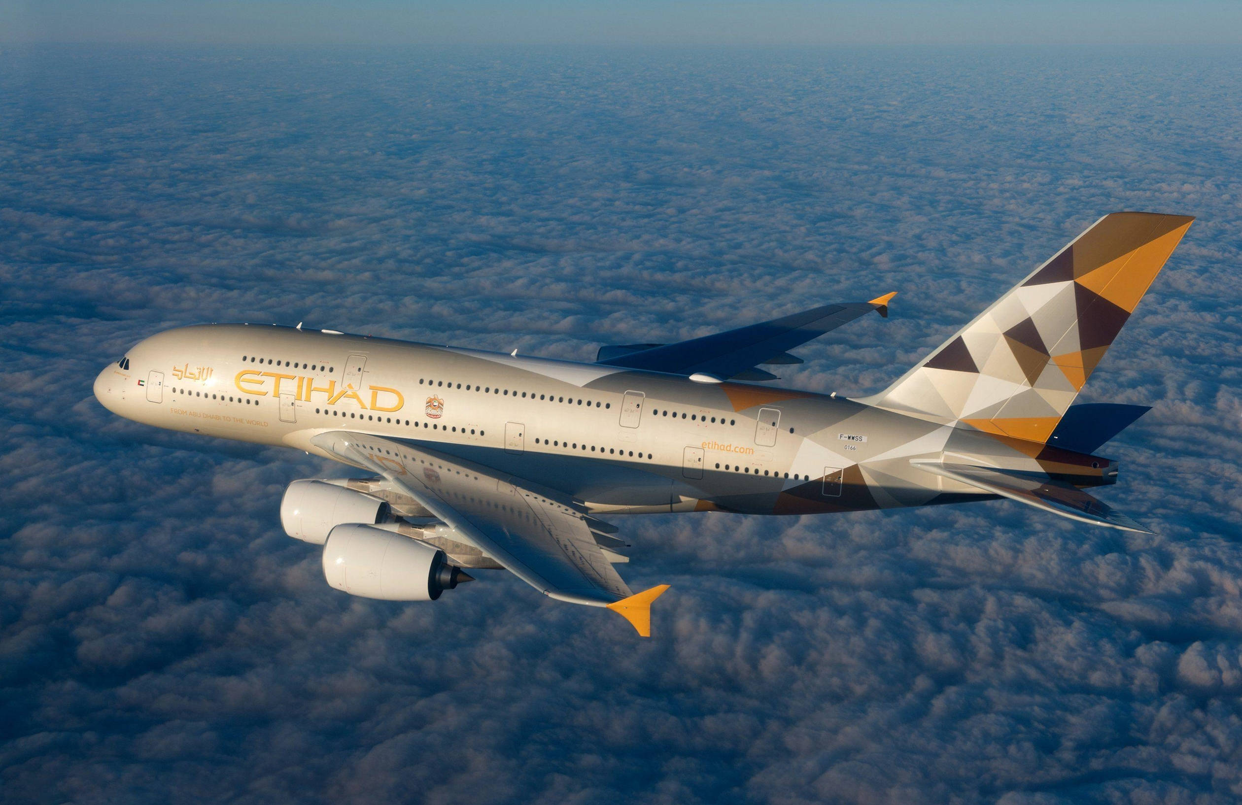 flying 桌布 壁紙 — 一架流線型的阿提哈德航空空中巴士A380在晴朗藍天下翱翔於廣闊的 fluffy 白雲海洋之上。